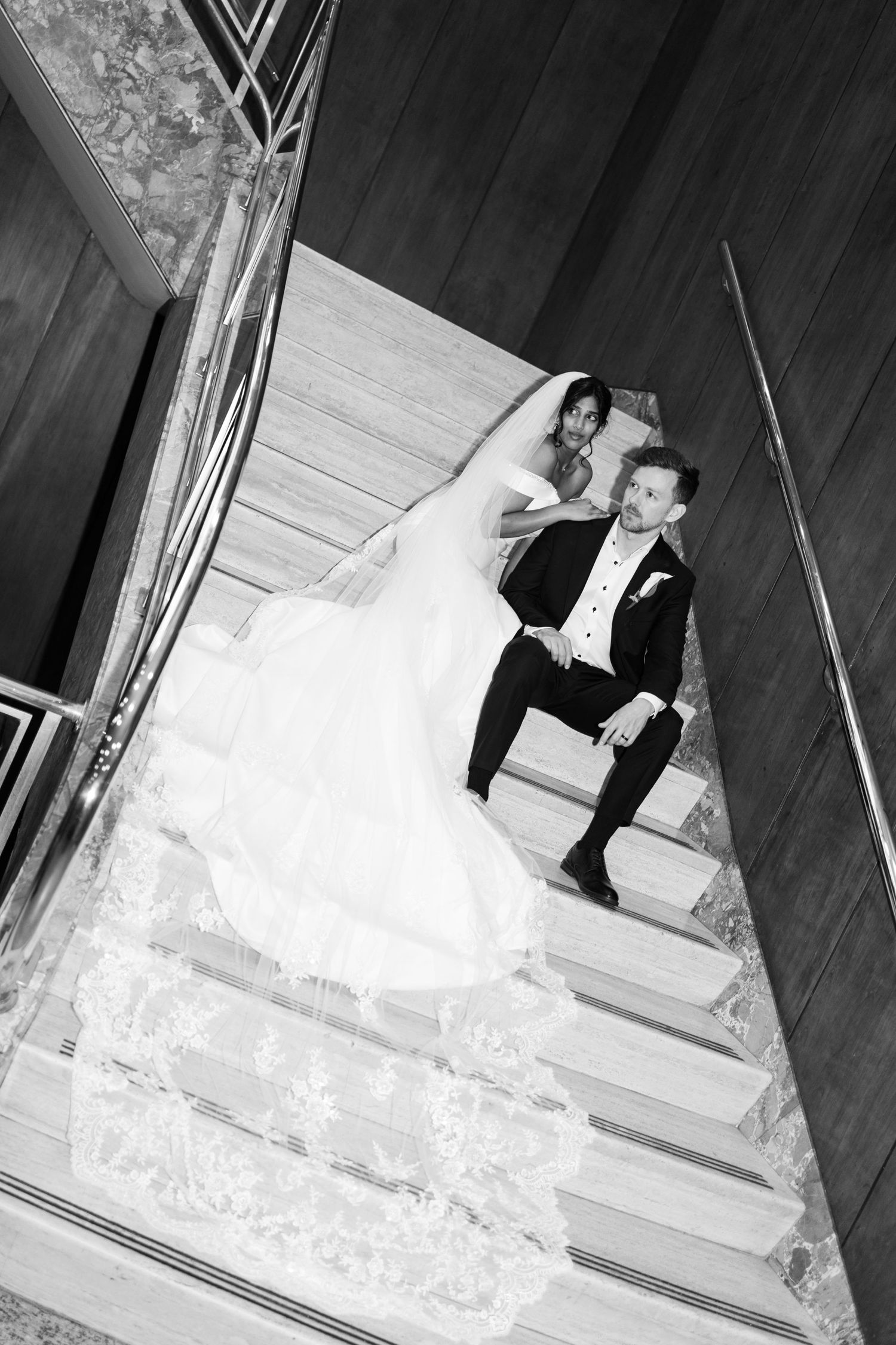 A sequence of black and white photos showing a couple in wedding attire descending a staircase together in Halifax, Nova Scotia.