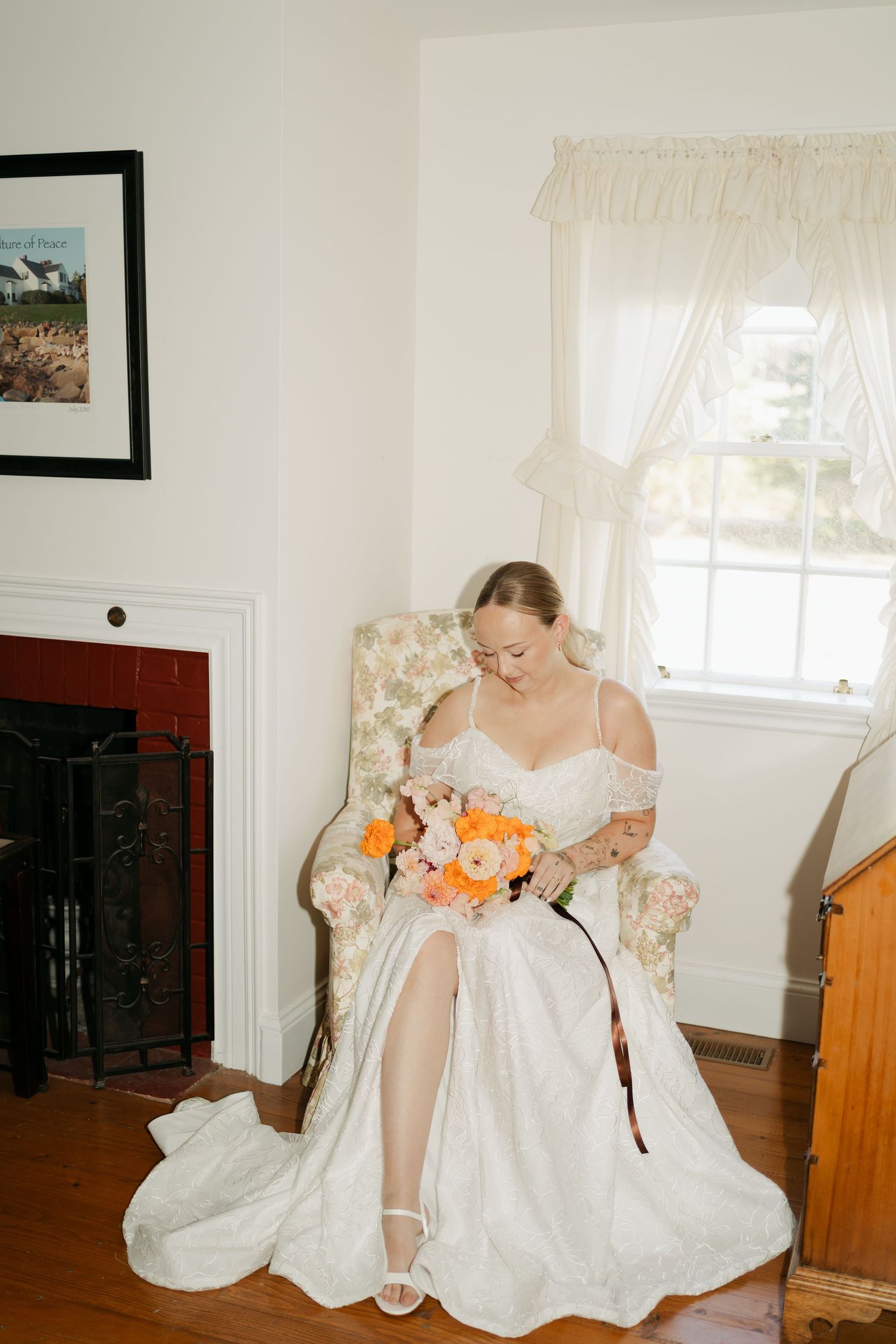 Wedding dress detail shot with orange and peach floral bouquet in an interior setting in Nova Scotia.