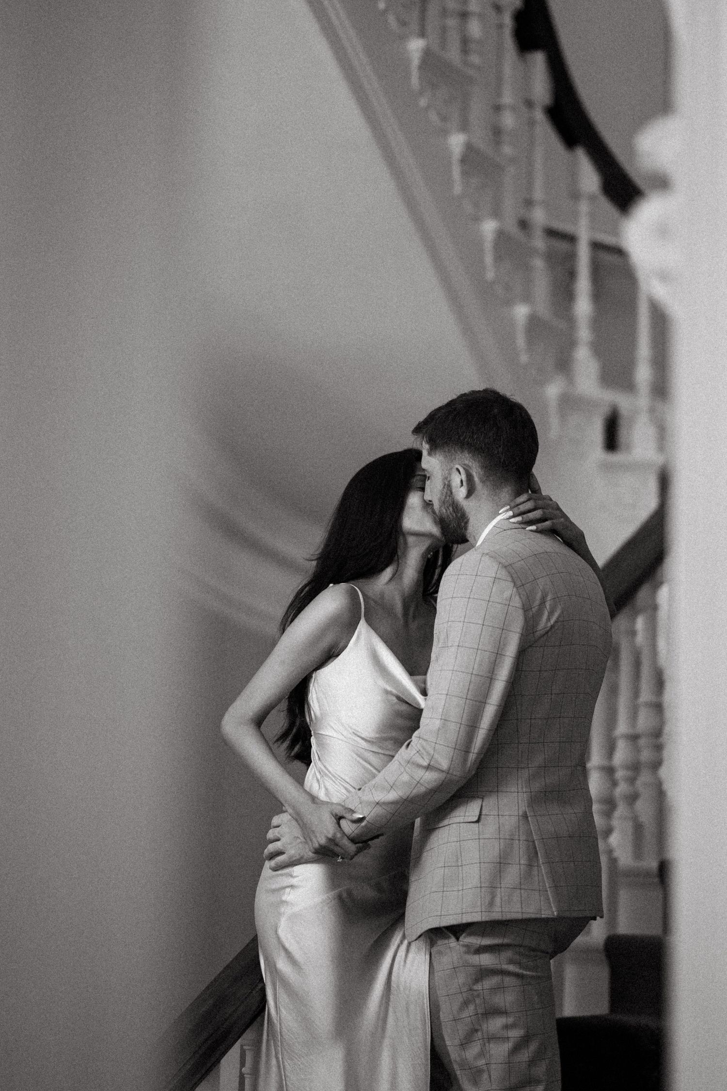 A romantic black and white photo series showing a couple embracing and dancing in an elegant interior space in Halifax, Nova Scotia.