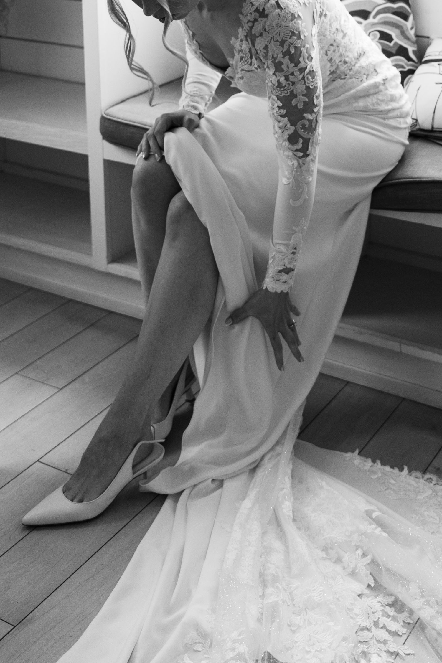 Black and white photos showing details of a bride putting on wedding shoes and dress at Lightfoot & Wolfville.