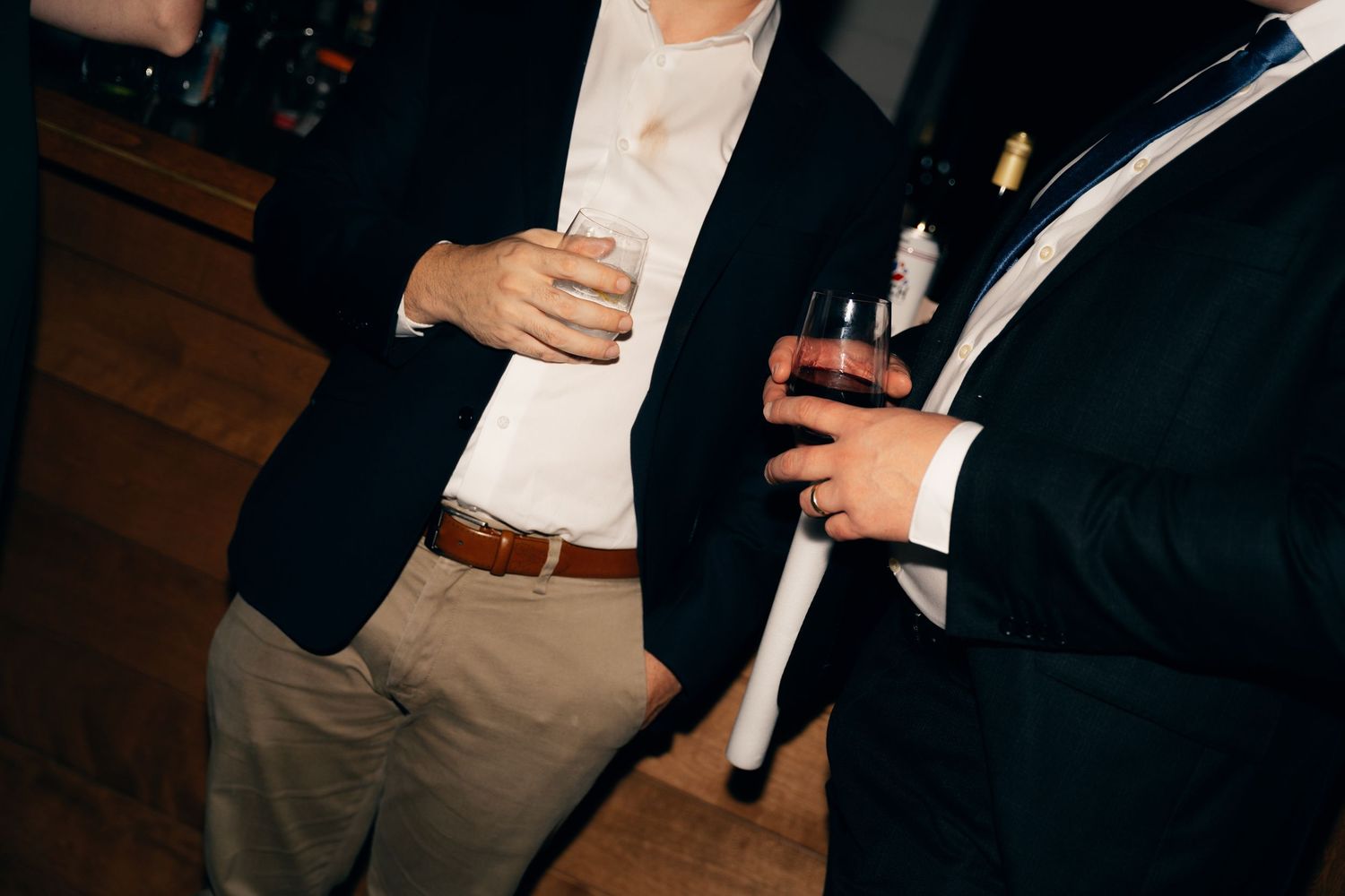 Guests mingling and holding drinks at an elegant evening reception with warm lighting at Lightfoot & Wolfville.