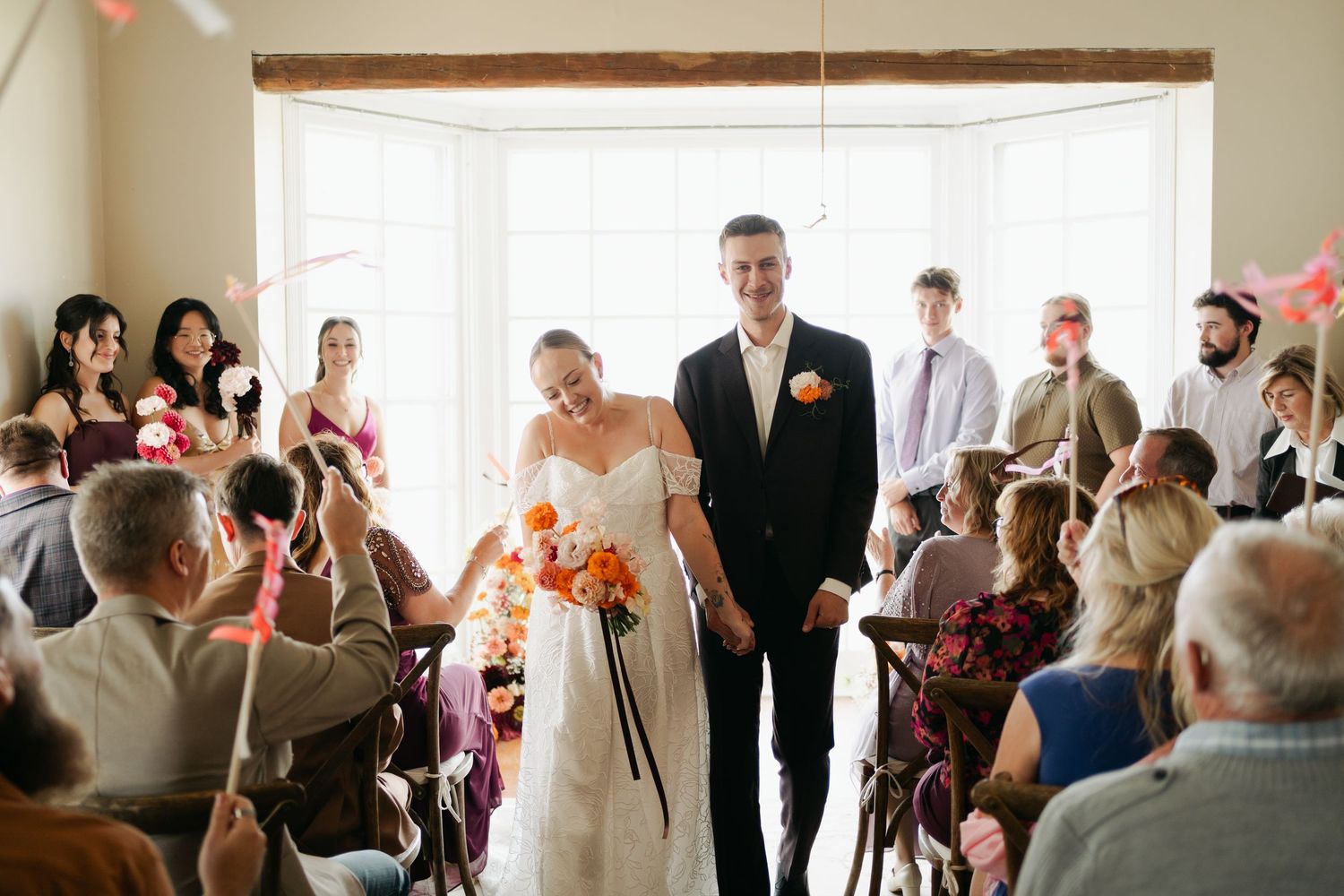 Wedding guests gather in a bright indoor venue to celebrate during a joyous reception ceremony in Nova Scotia.