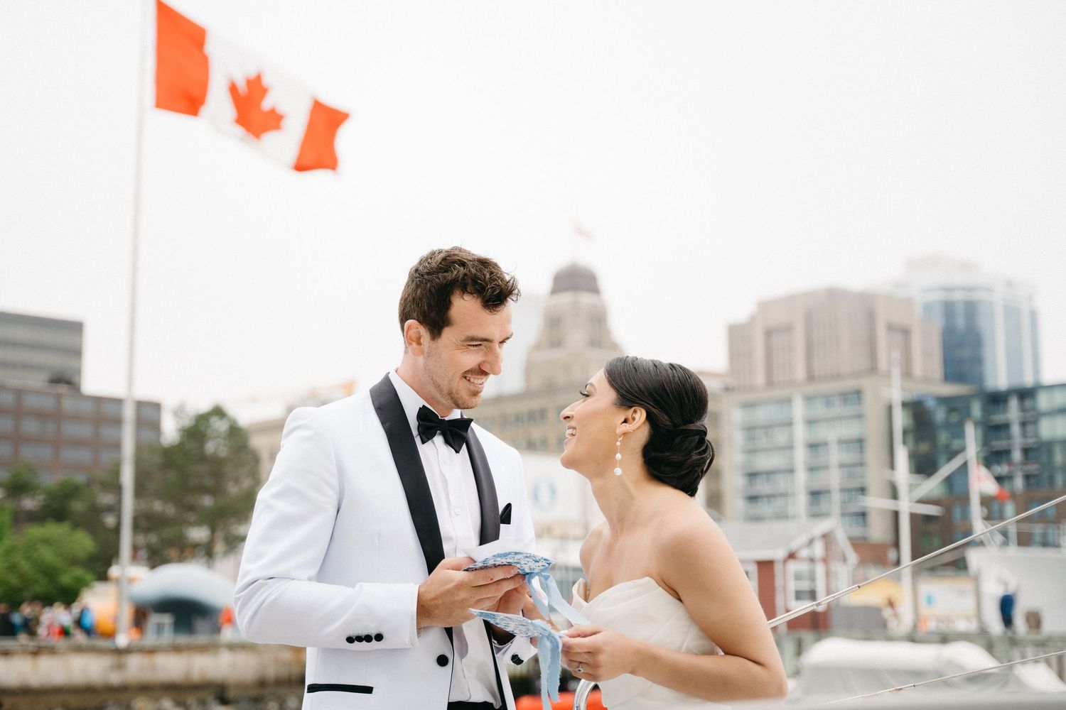 A couple shares a romantic moment while toasting champagne glasses at their outdoor wedding celebration in Halifax, Nova Scotia.