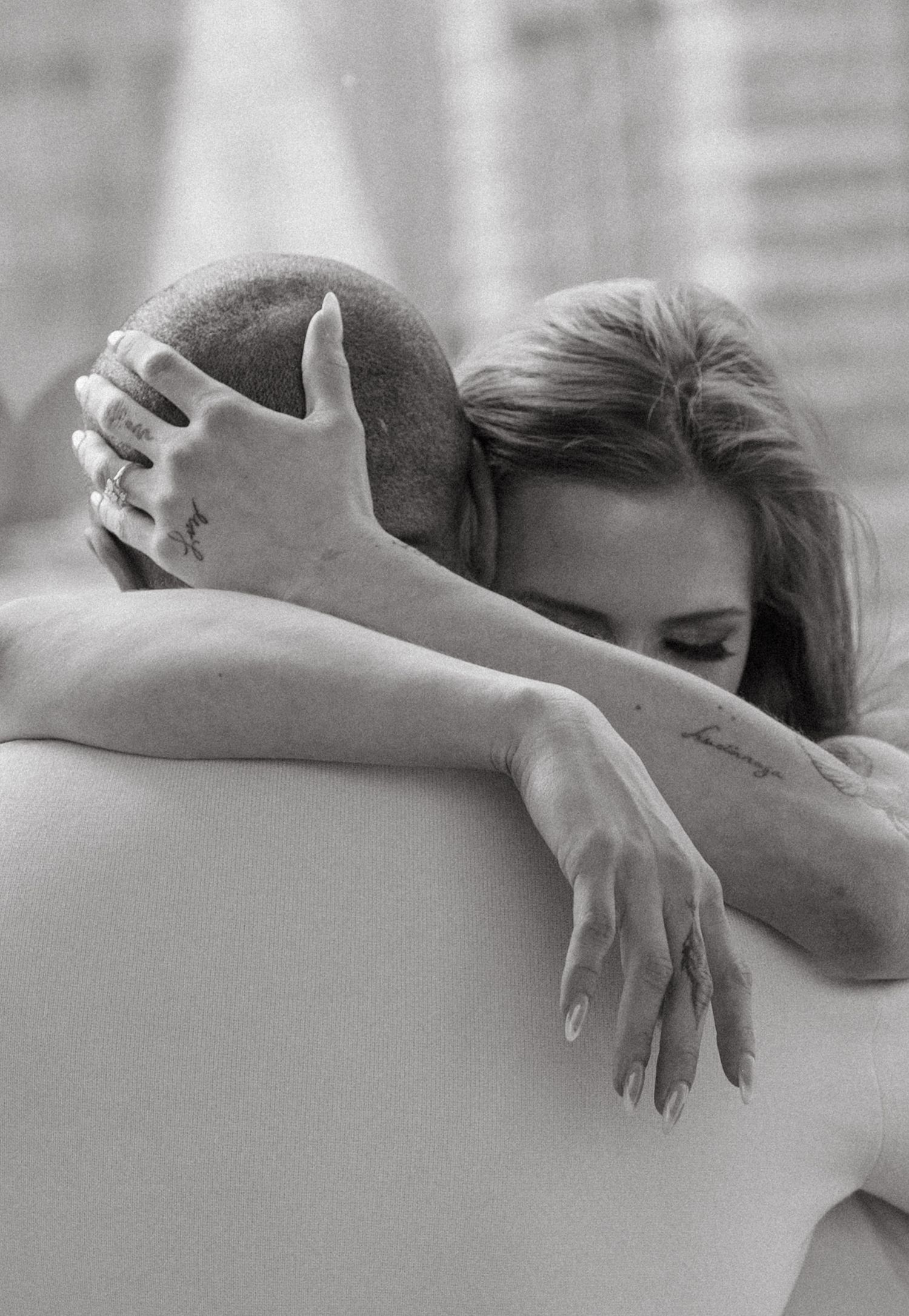 An intimate black and white photograph capturing a tender embrace between two people in Montreal, Quebec.