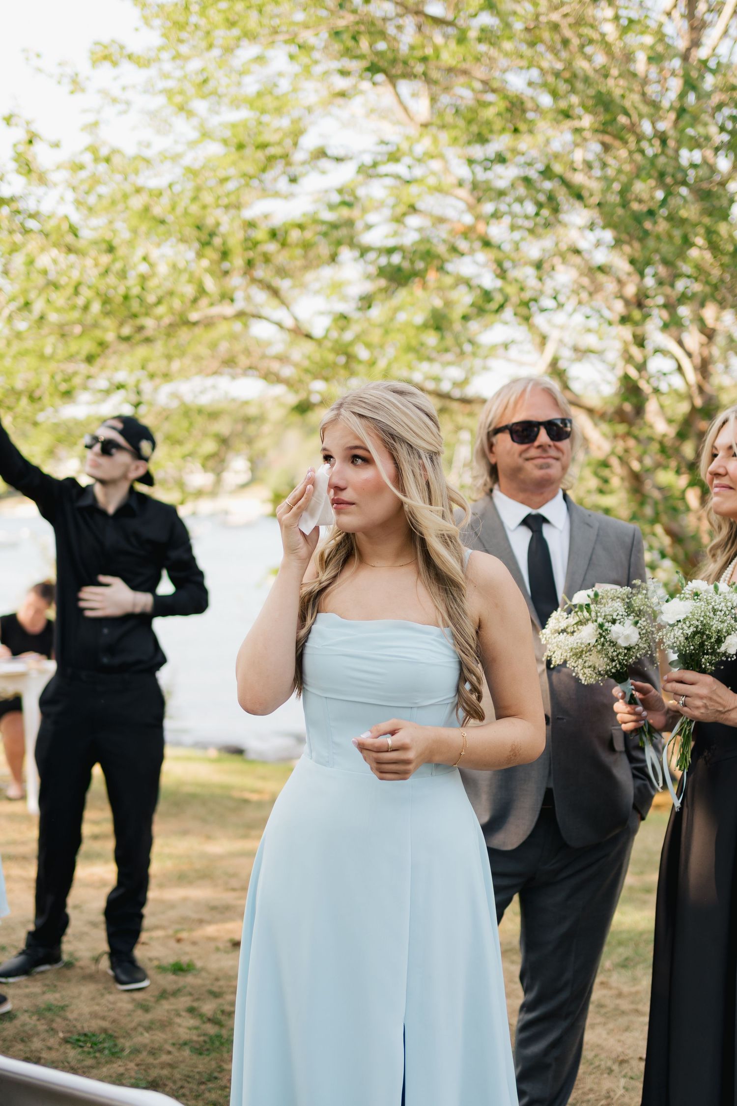 Bridesmaids in light blue dresses gather outdoors during a wedding celebration in Halifax, Nova Scotia.