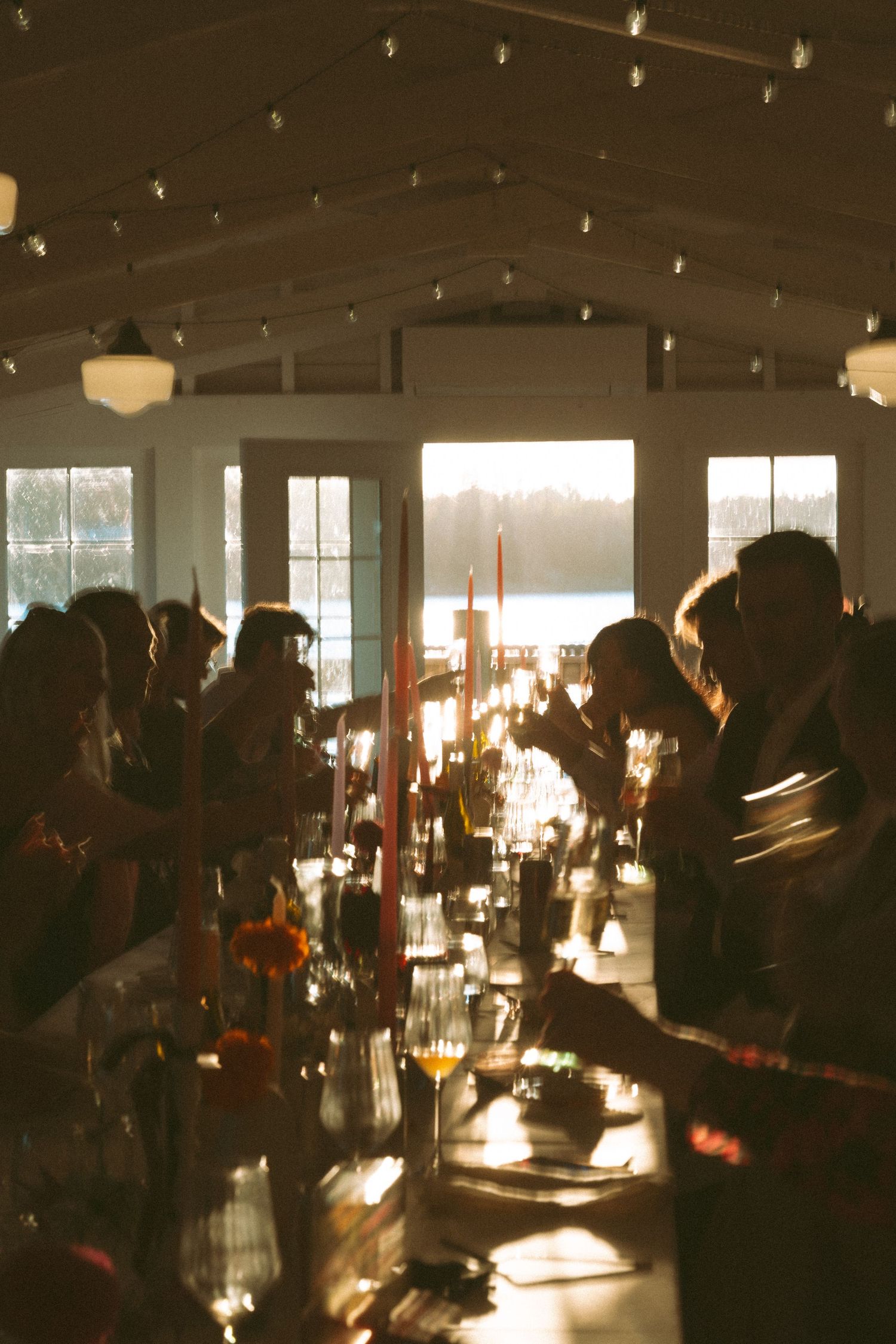 Dimly lit reception venue with guests seated at tables under string lights creating a romantic ambiance in Nova Scotia.