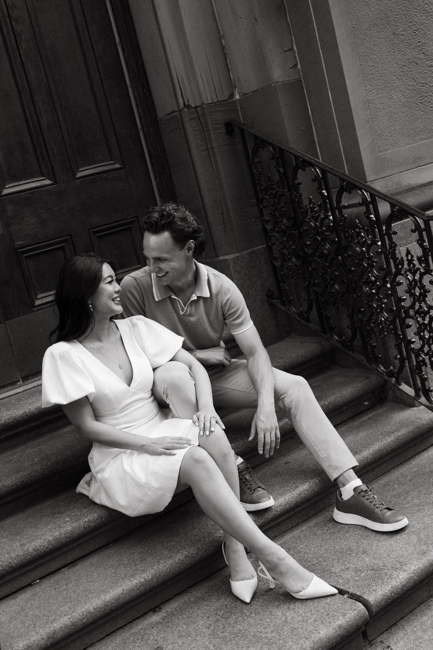 A couple sits together on stone steps in downtown Halifax, Nova Scotia sharing an intimate black and white moment.