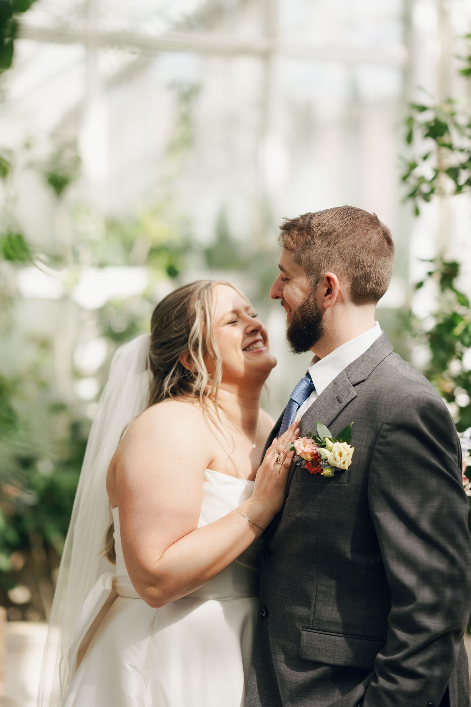 A romantic wedding kiss sequence captured in a bright greenhouse setting with natural light in Halifax, Nova Scotia.