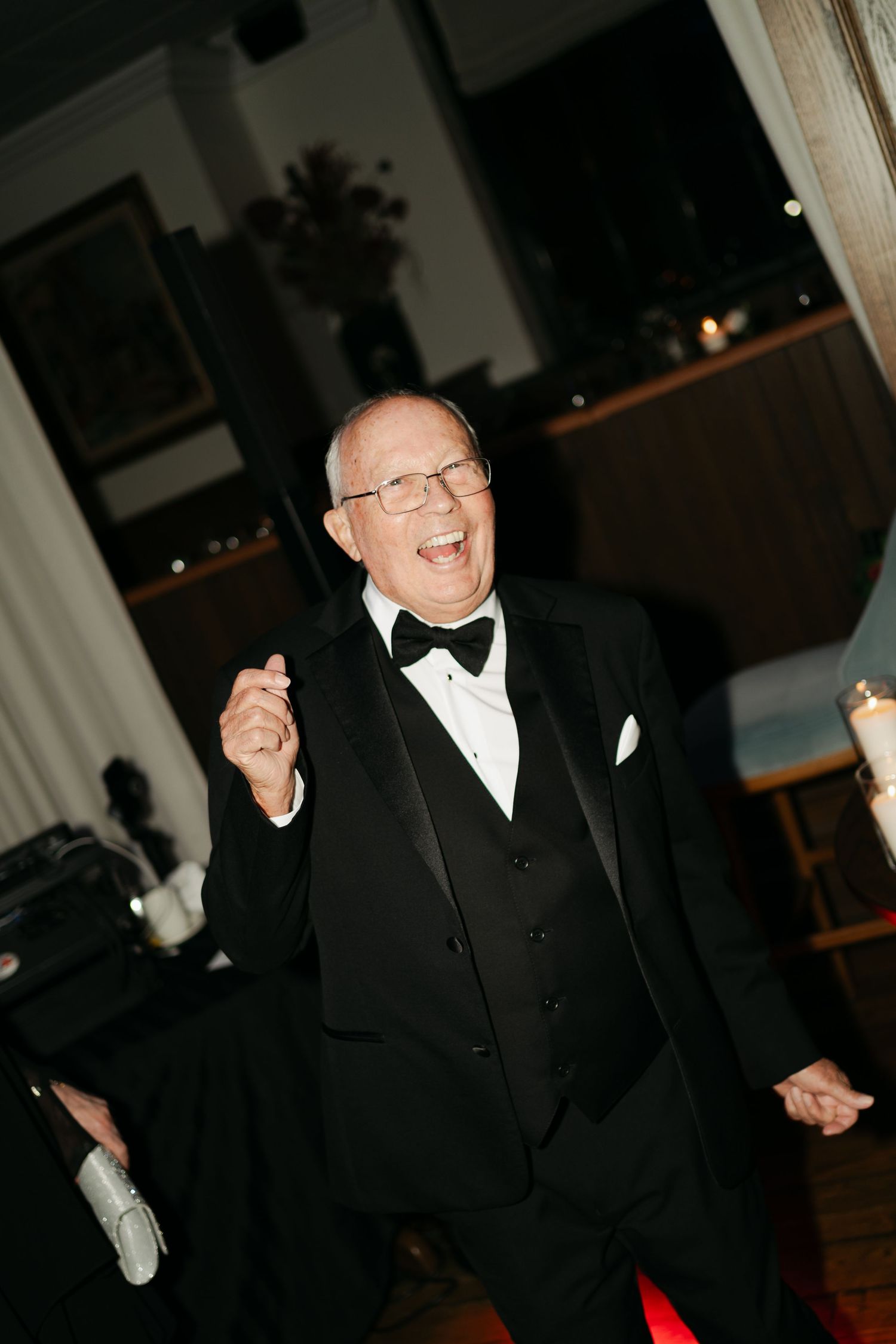 A person in a black tuxedo and bow tie dances joyfully at a formal event at Lord Nelson Hotel, Halifax, Nova Scotia.