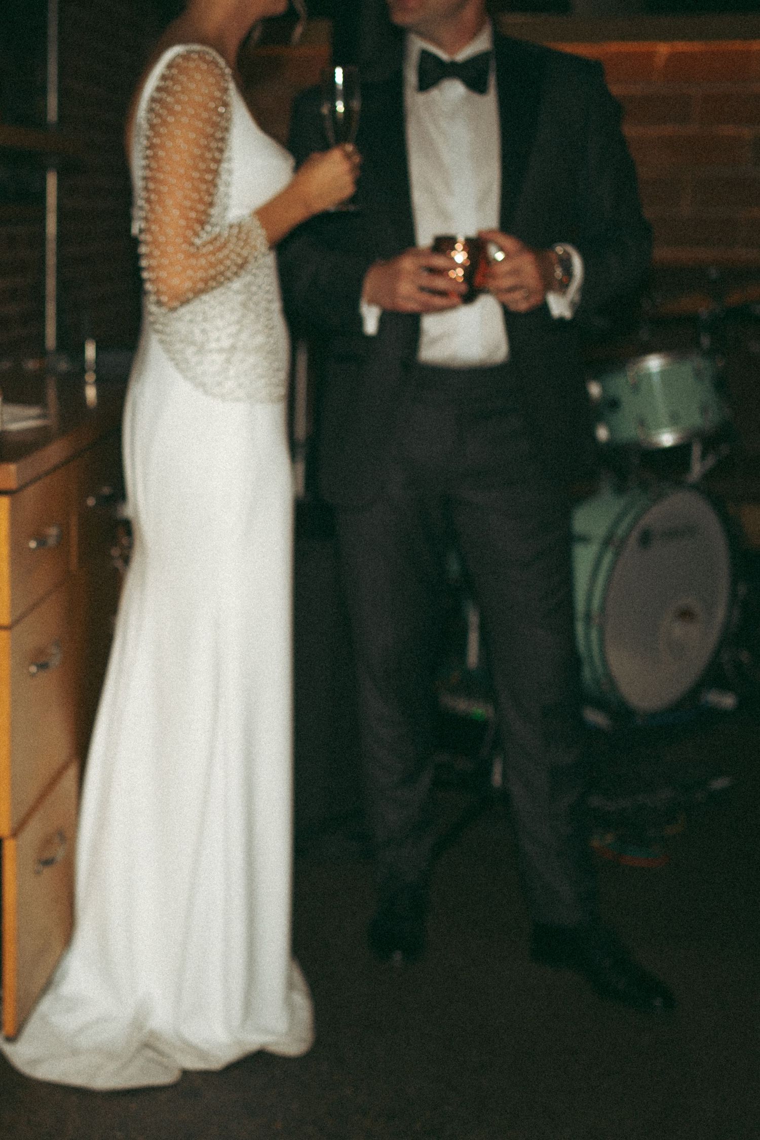 A couple in formal wedding attire dance together during their reception as guests watch in a dimly lit venue in Halifax, Nova Scotia.