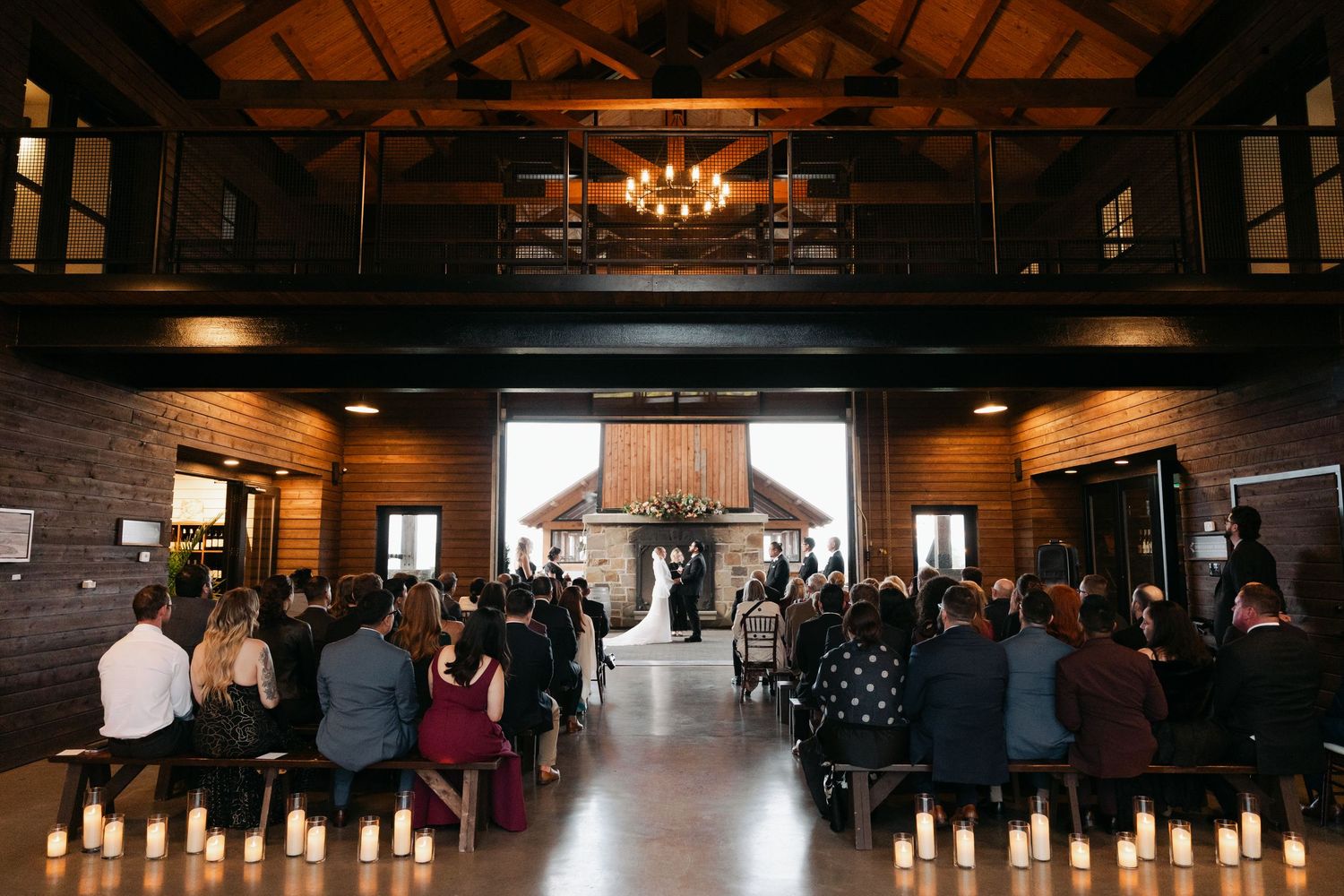 Wedding reception venue with rustic wooden beams and elegant chandeliers creating a warm, romantic atmosphere at Lightfoot & Wolfville.