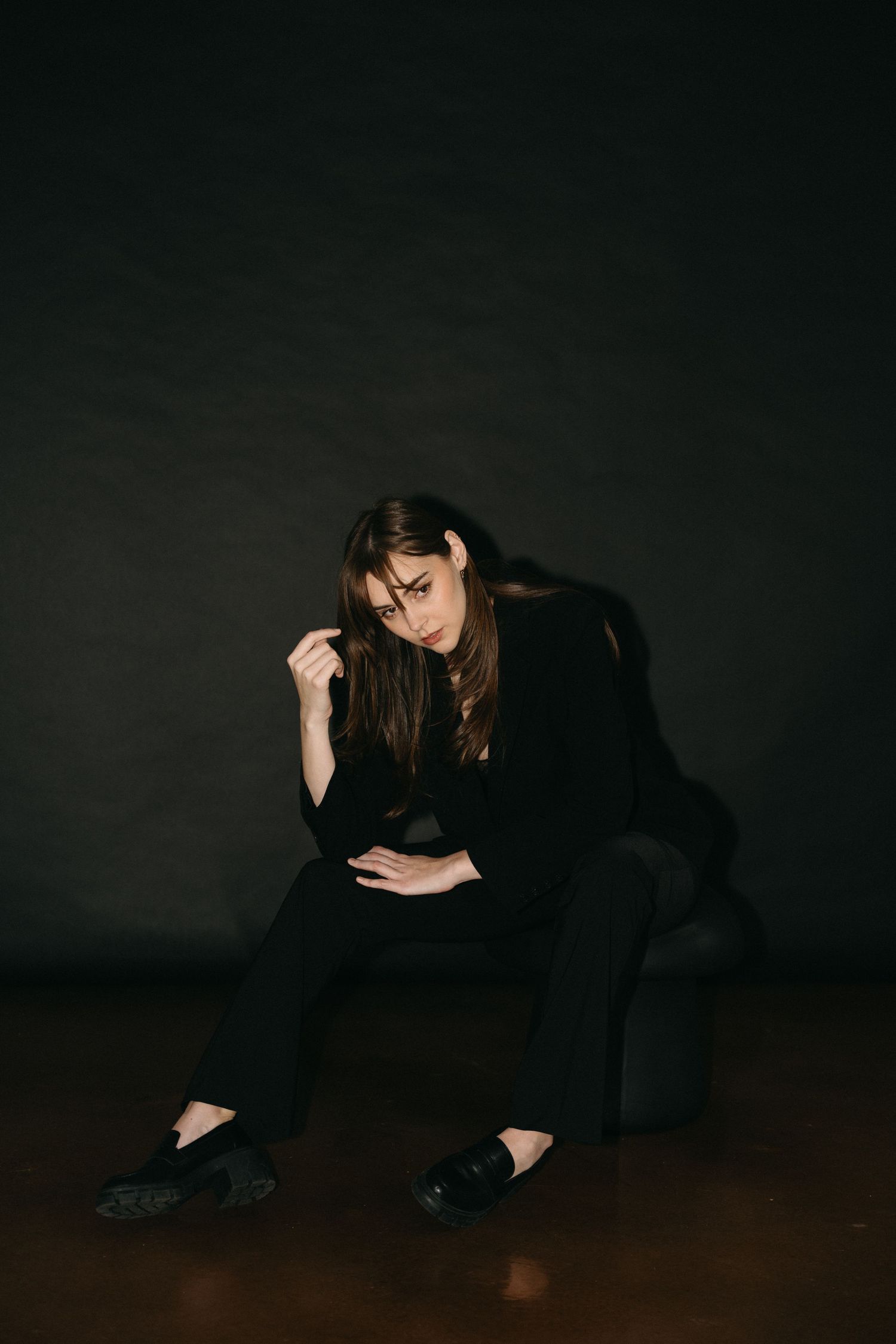 Figure in dark clothing positioned low against shadowy background in artistic photo sequence in Halifax, Nova Scotia.