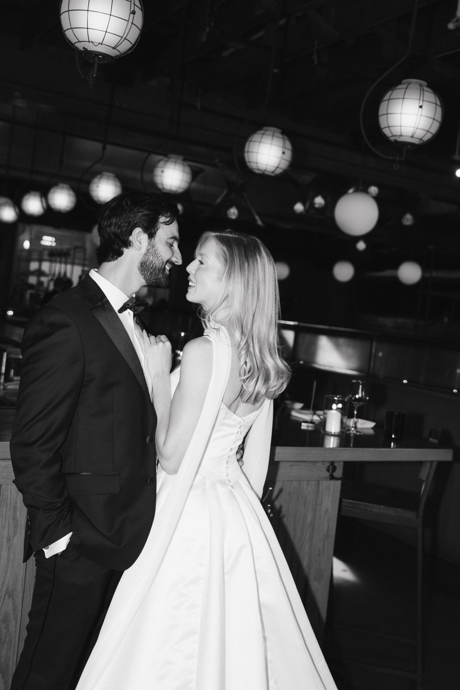 A black and white wedding photo series with paper lanterns hanging from the ceiling during a reception in Halifax, Nova Scotia.