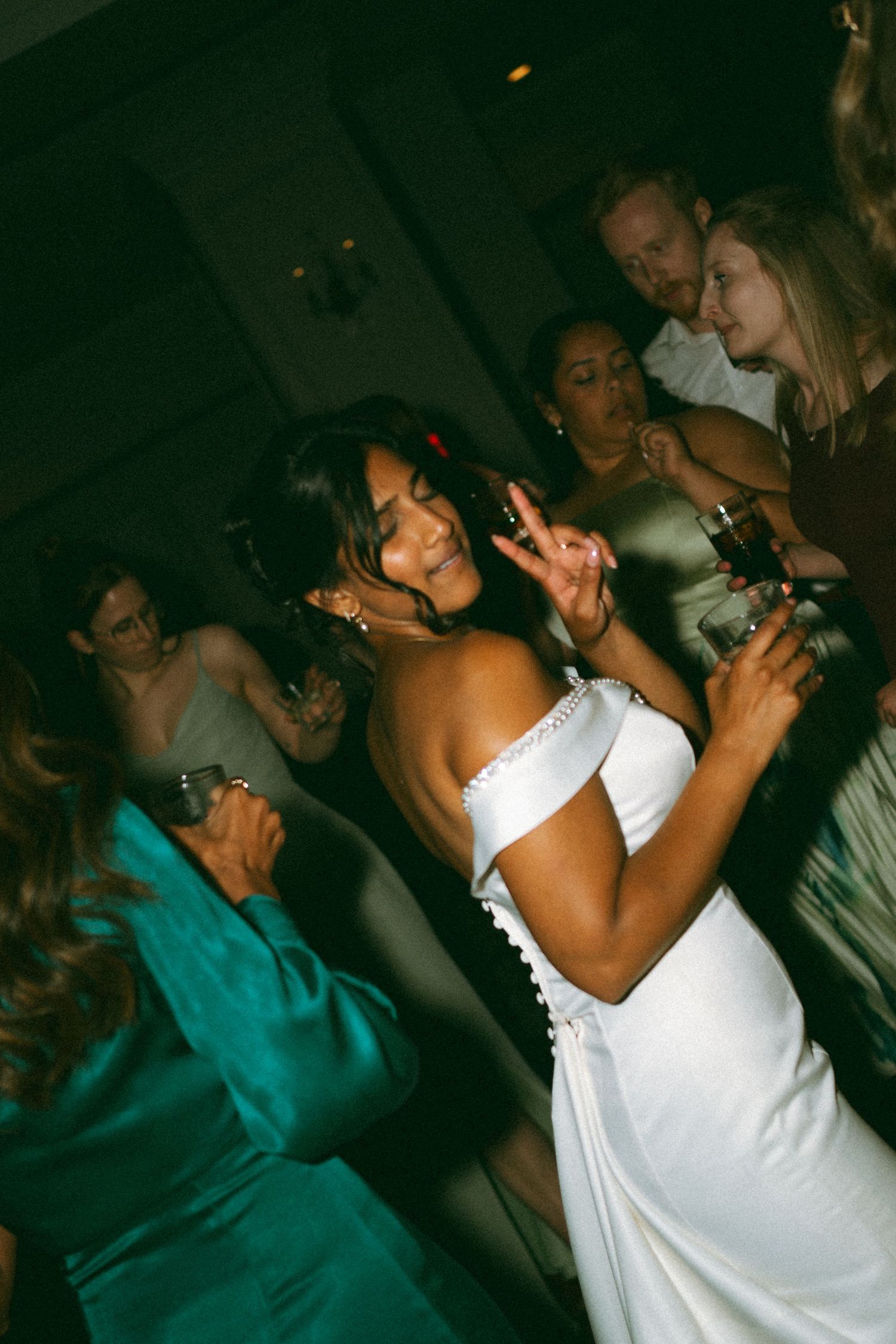 People dancing and celebrating at a dimly lit nightclub party with someone in a white dress visible in the crowd in Halifax, Nova Scotia.