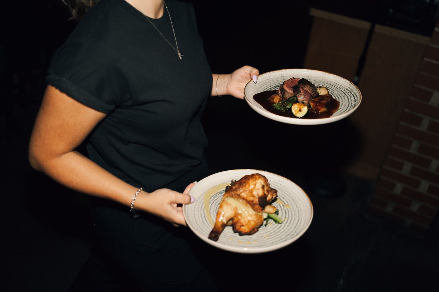 Multiple plates of elegantly plated food being served at a formal dining event in Halifax, Nova Scotia.