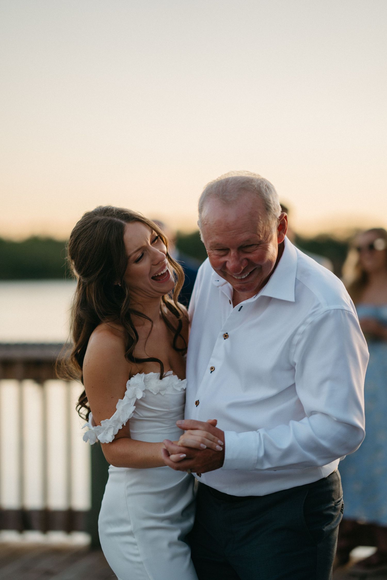 Candid sequence of a couple sharing genuine laughter during sunset by the waterfront in Halifax, Nova Scotia.