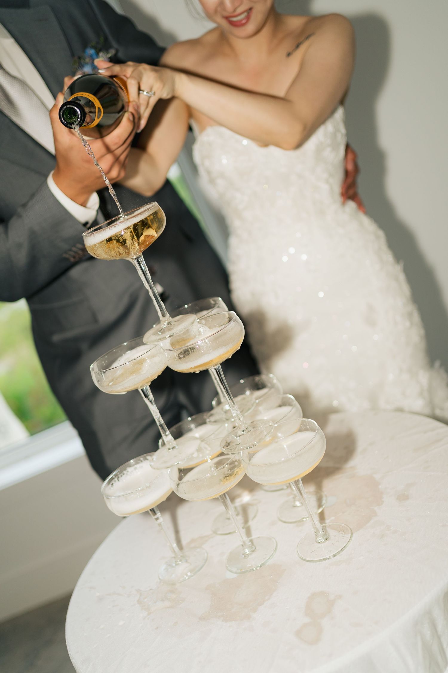 A champagne tower being poured at an elegant wedding celebration in Halifax, Nova Scotia.