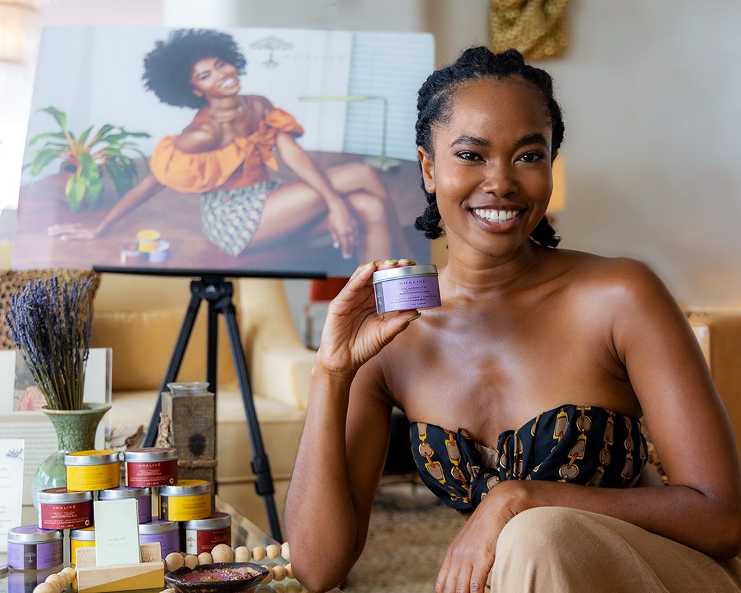 Black women smiling holding skincare product