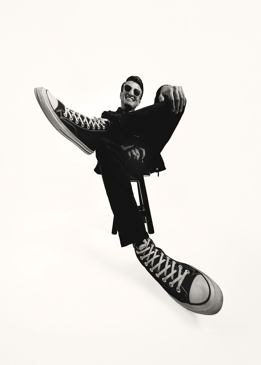 A sequence of black and white photos showing a classic Converse sneaker in different dynamic angles against a white background.
