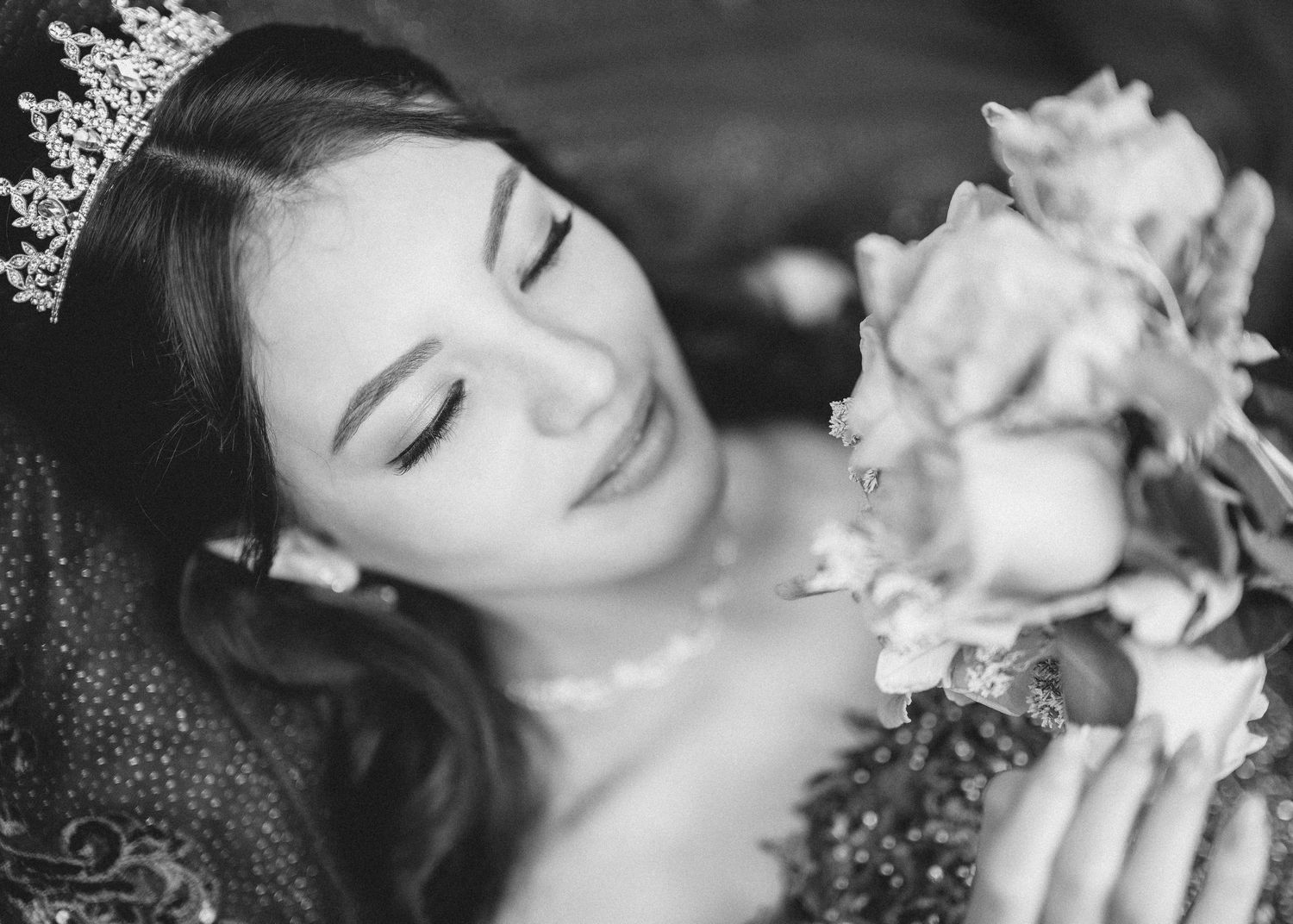 Black and white portraits of a woman with flowers in romantic poses.