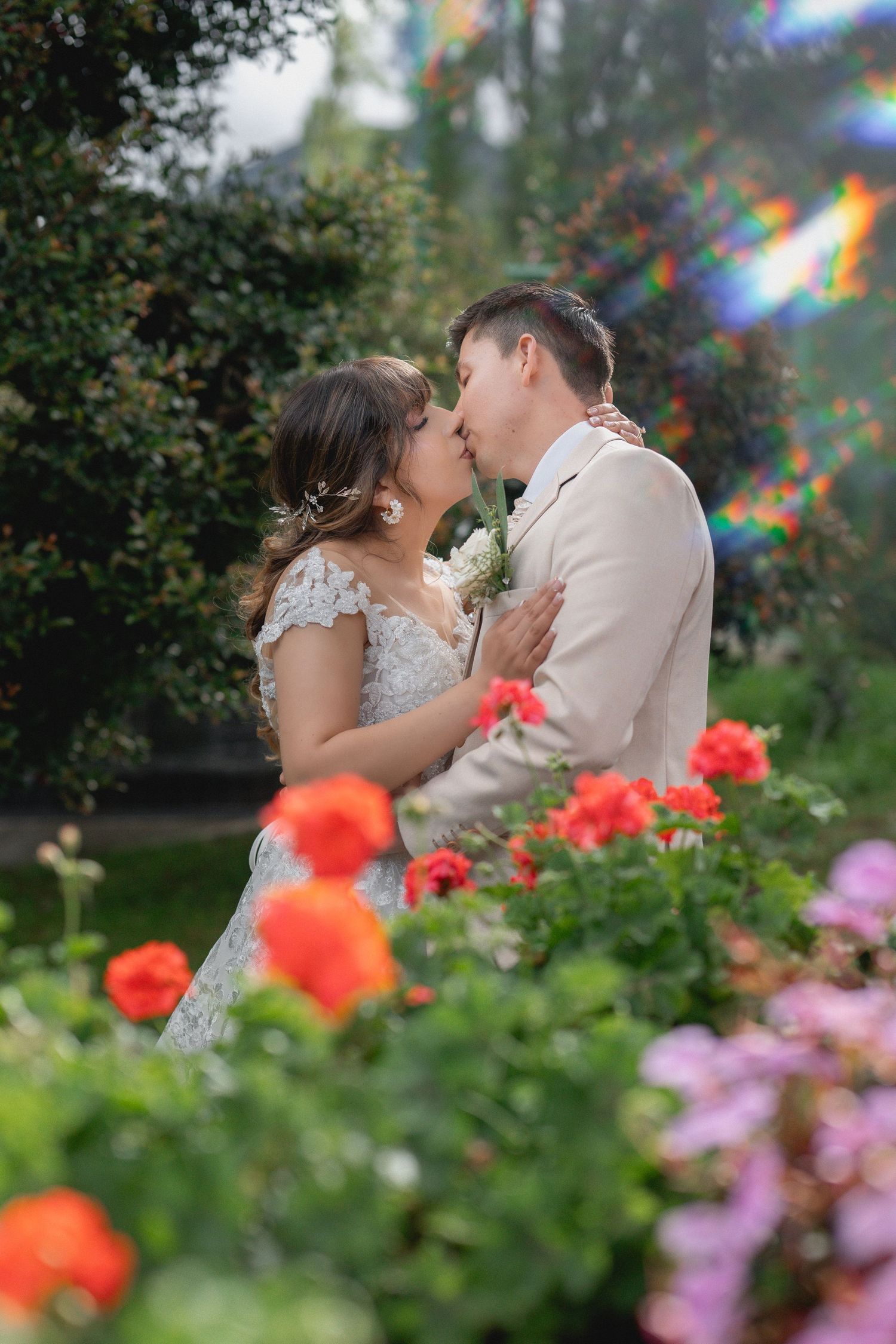 A romantic moment captured in a garden with vibrant orange poppies and pink flowers blooming in the foreground.