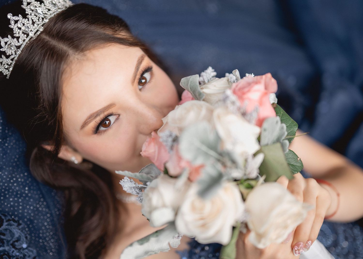 A person playfully smashes their face into a beautiful pink and white frosted cake.