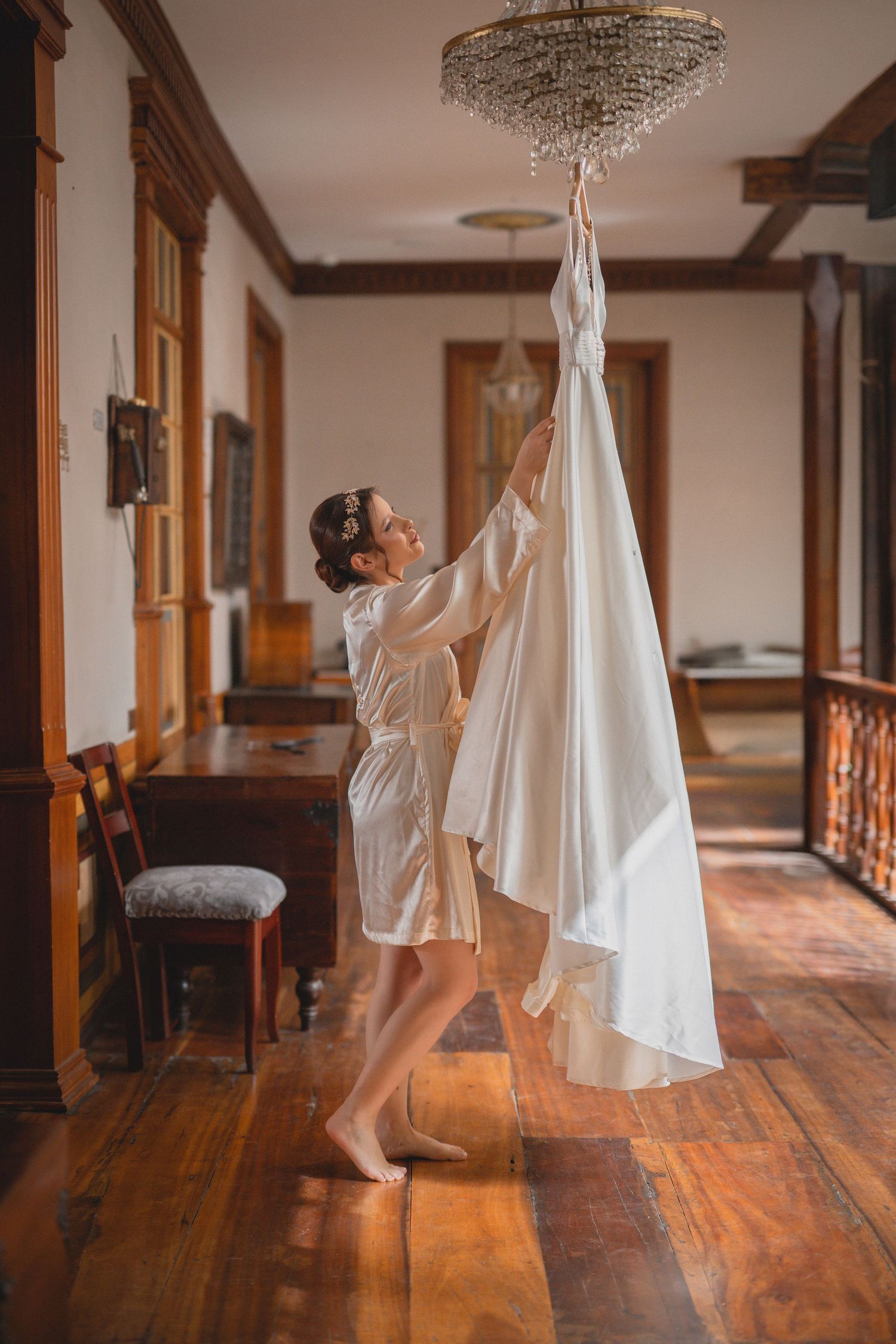 A sequence of dance movements captured in a hallway with wooden floors and a white dress flowing in motion.