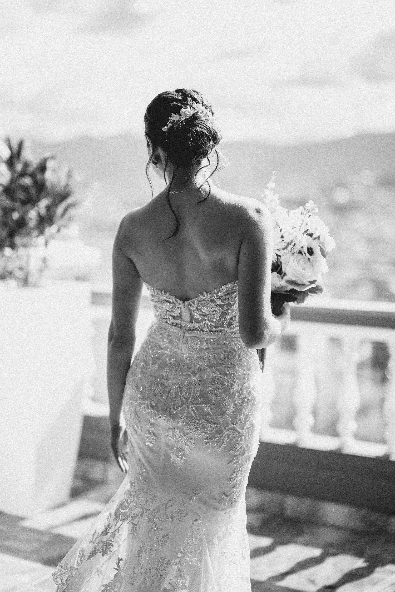A bride in a lace strapless wedding dress shown from behind in a series of black and white photographs.