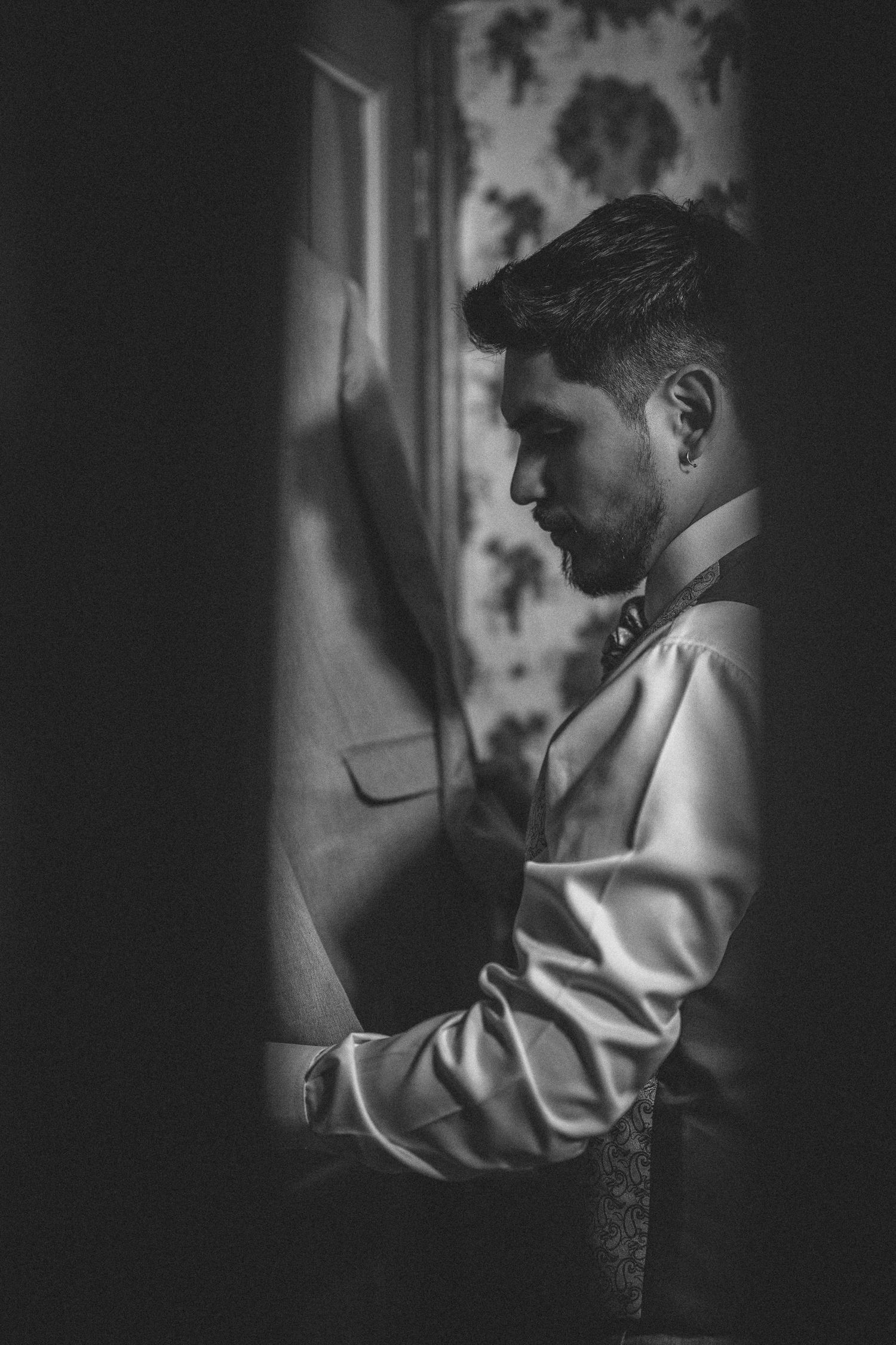 Black and white intimate wedding portraits showing tender moments between a couple in dramatic lighting.