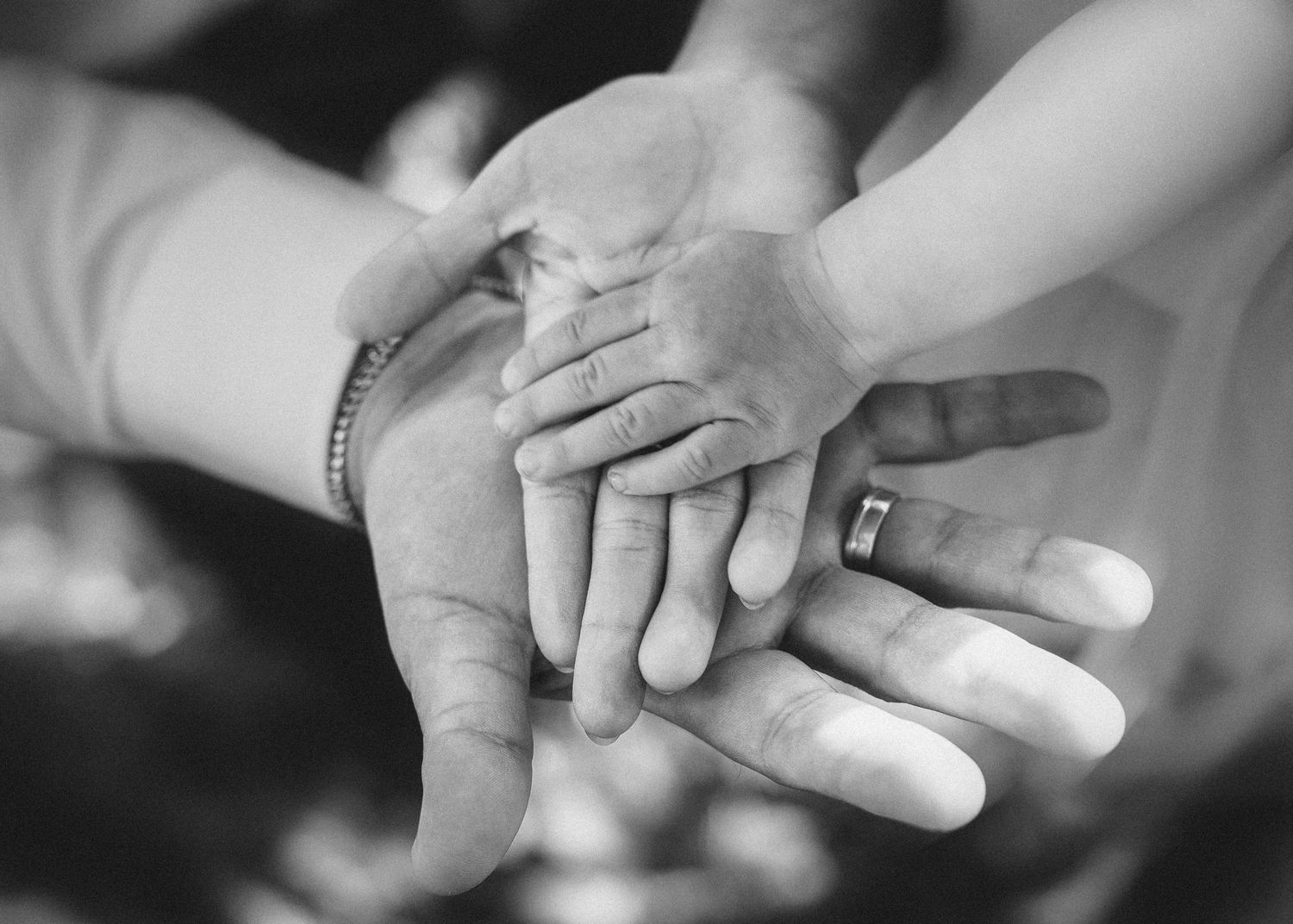 Close-up view of hands exchanging wedding rings during a marriage ceremony.