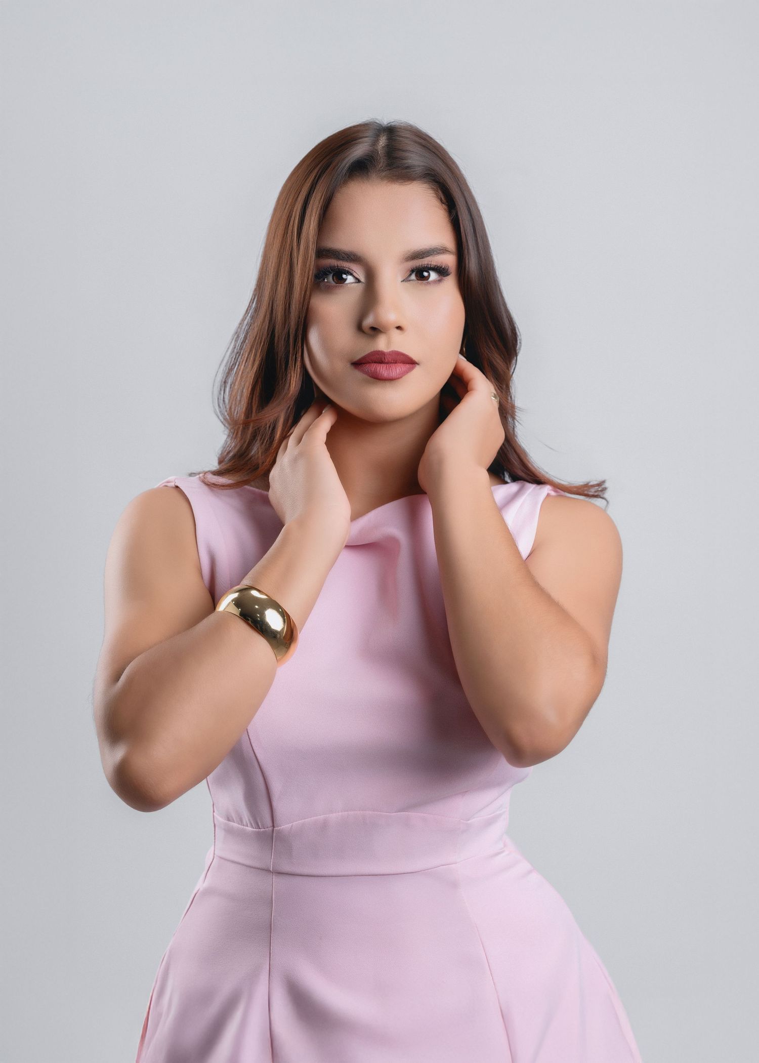 Model in soft pink sleeveless dress poses against gray background in multiple elegant poses.
