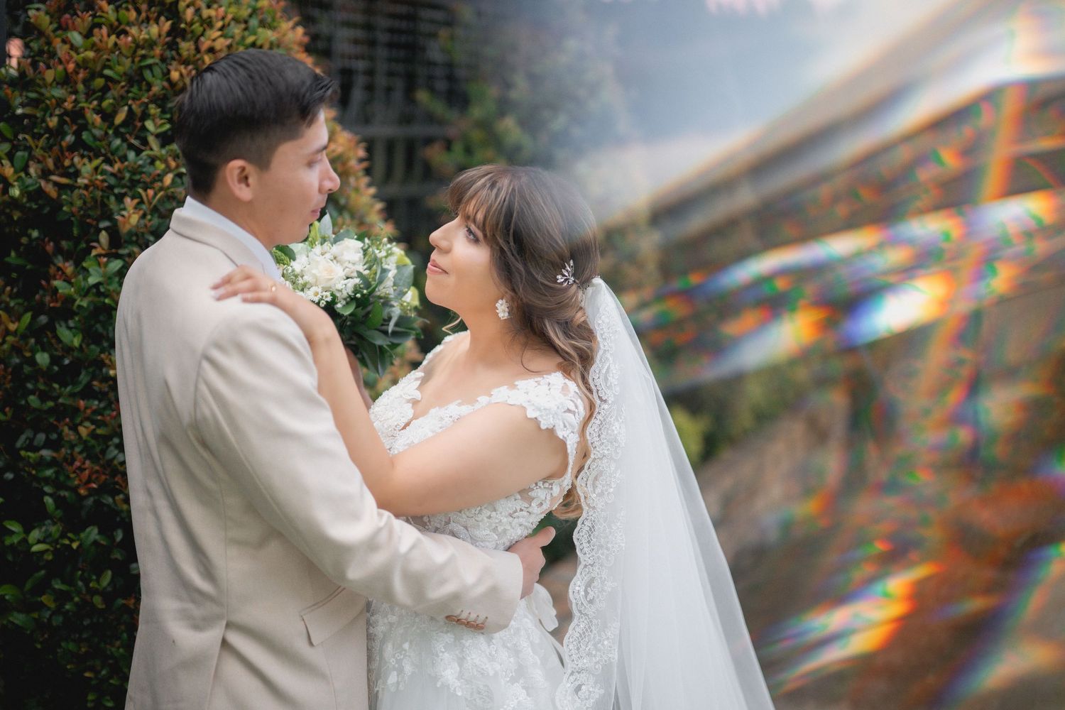 Romantic wedding dance captured in soft lighting with floral decorations and sunlight streaming through windows.