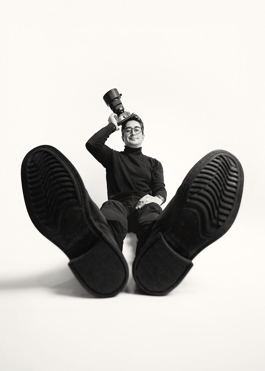 Black and white sequence showing a person in dark clothing curled up and rolling across a white background.