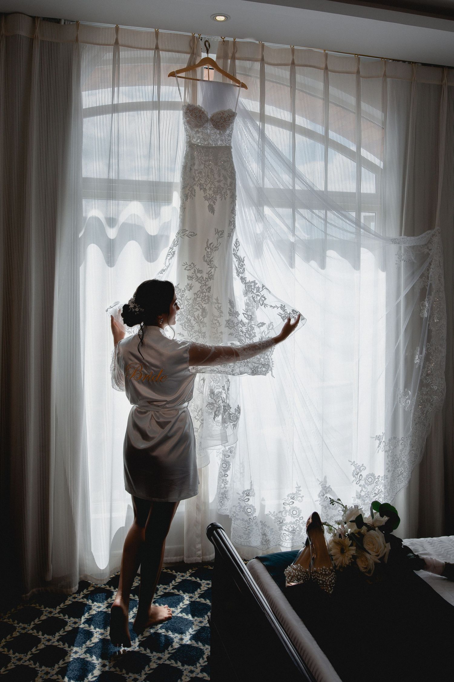 A person adjusts sheer white curtains in front of bright windows in a room, shown in a sequence of movements.