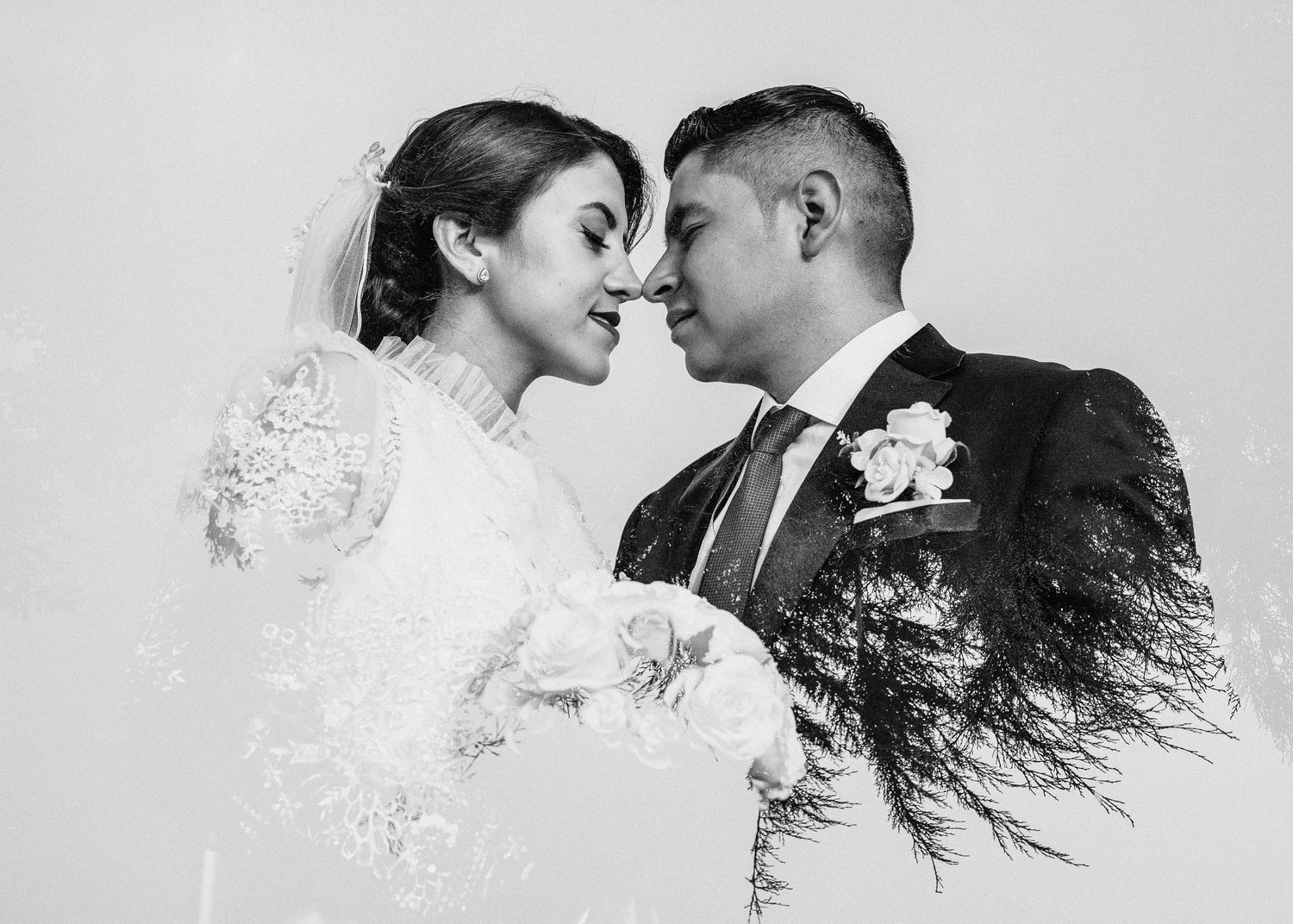 A creative double exposure wedding portrait combines silhouettes with tree branches against a light background.