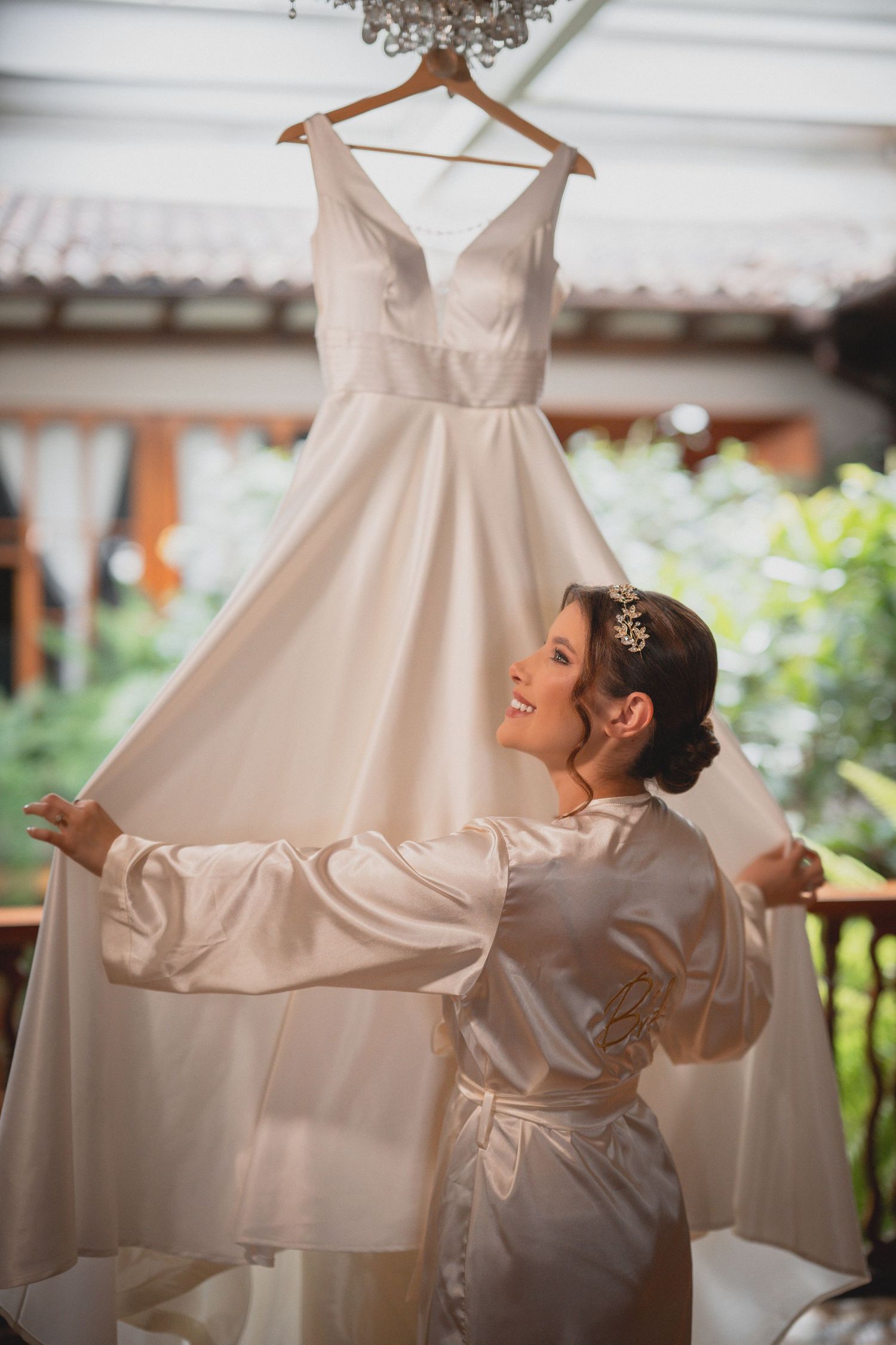 A sequence of photos showing a wedding dress being held up against natural light in a getting ready room.