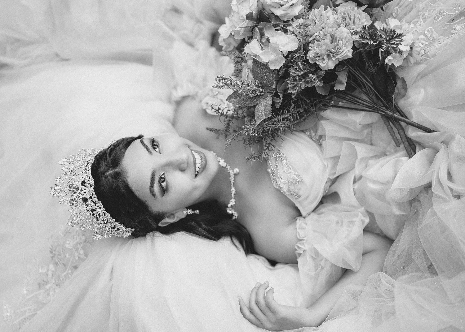 A dreamy black and white photo series showing a figure in flowing white fabric laying against soft textures.