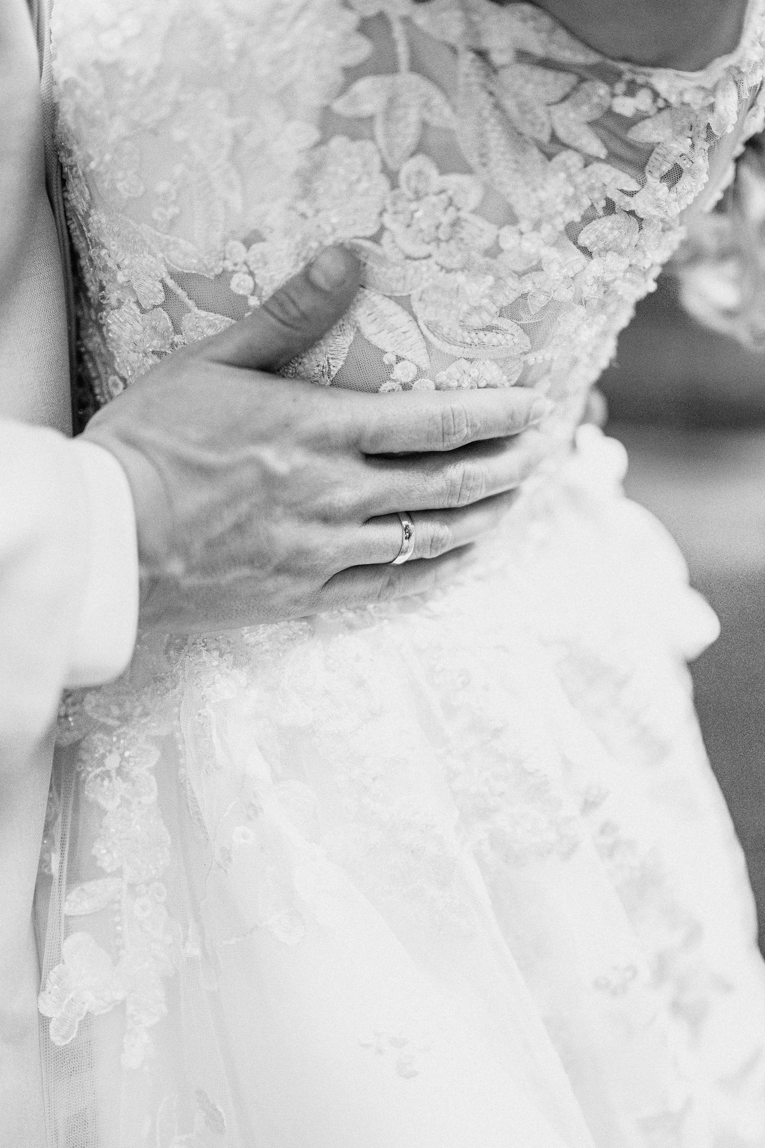 A series of black and white close-up photos showing intricate lace details on a wedding dress.