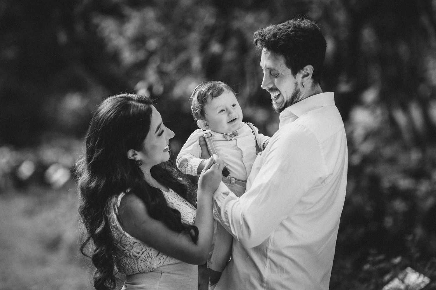 A tender family moment captured in black and white photography as they share joyful interactions outdoors.