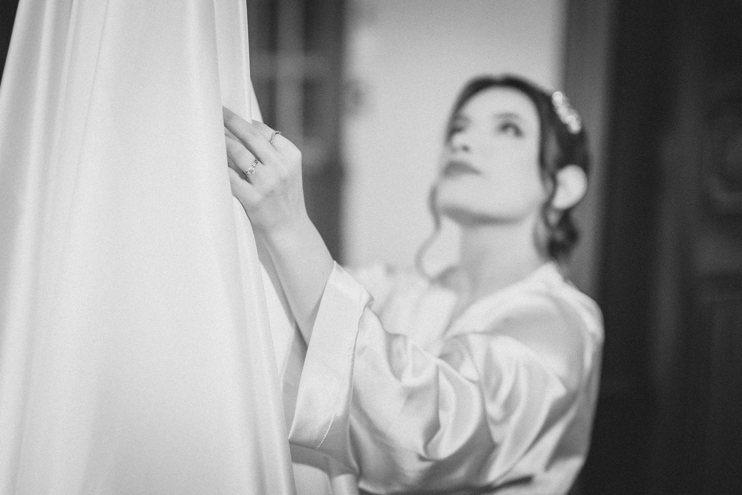 A black and white artistic portrait of a person looking upward in dramatic lighting.