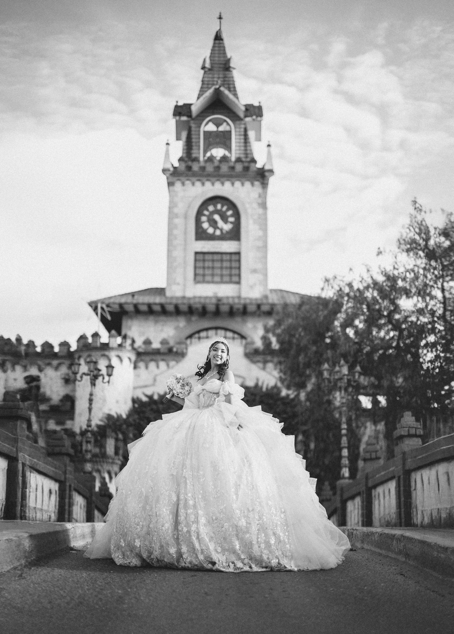 A bride in a flowing white gown poses at a castle-like venue with a clock tower in multiple romantic shots.