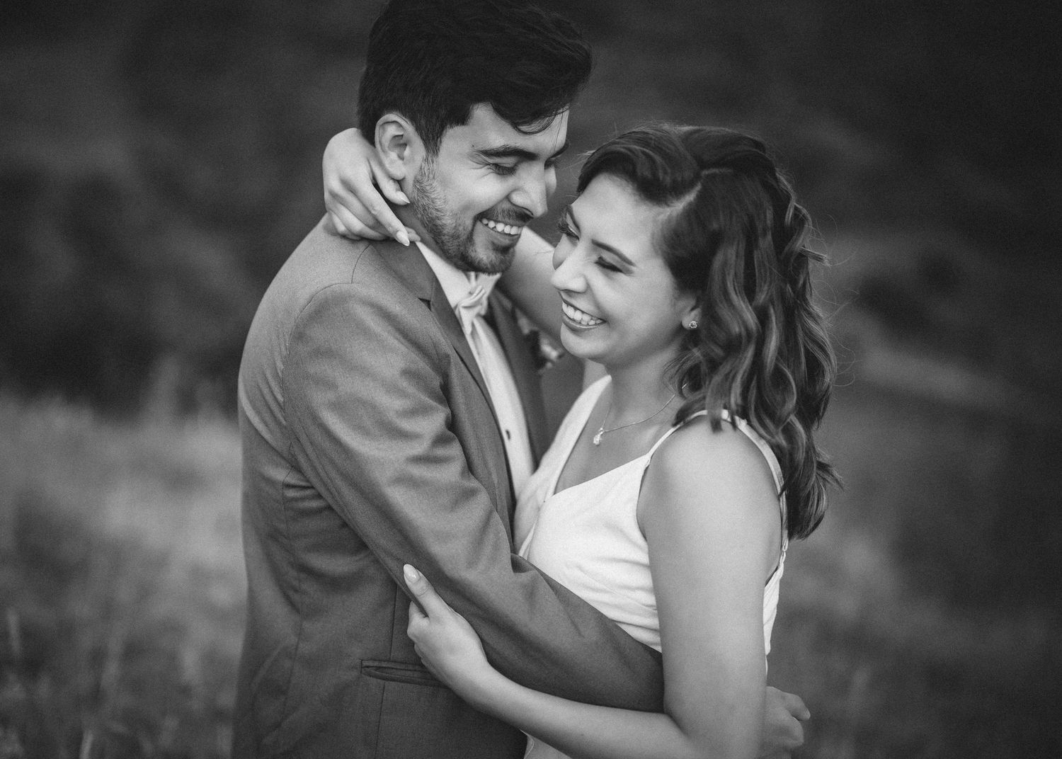 A romantic black and white photo series showing a couple embracing and sharing tender moments together.