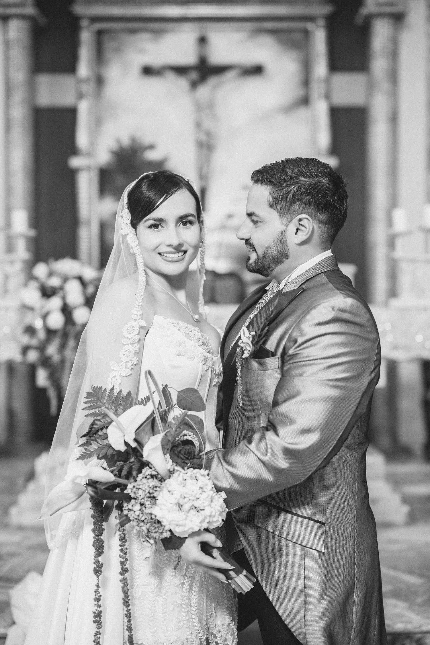 A black and white wedding photo series showing a happy couple embracing and laughing together in formal attire.