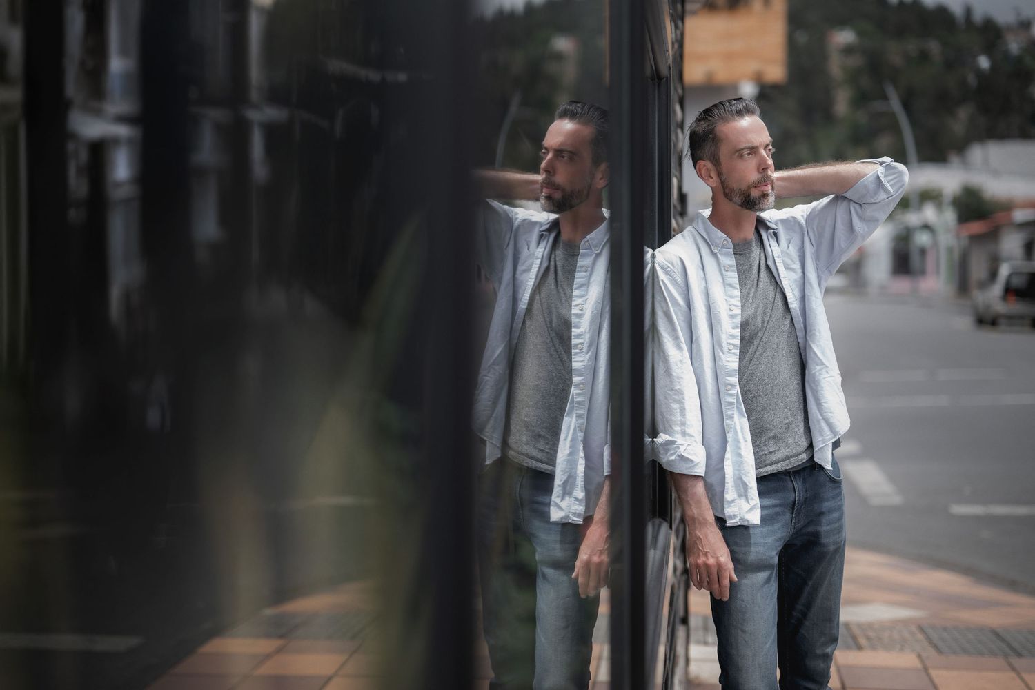 Multiple people in casual attire walking and conversing on an urban sidewalk with buildings in the background.