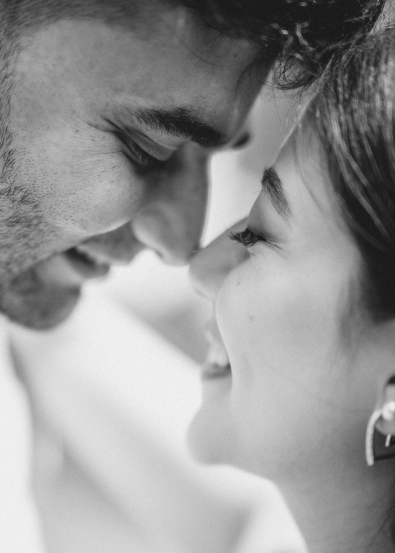 A black and white close-up photo sequence showing a romantic couple about to kiss in soft, dreamy lighting.