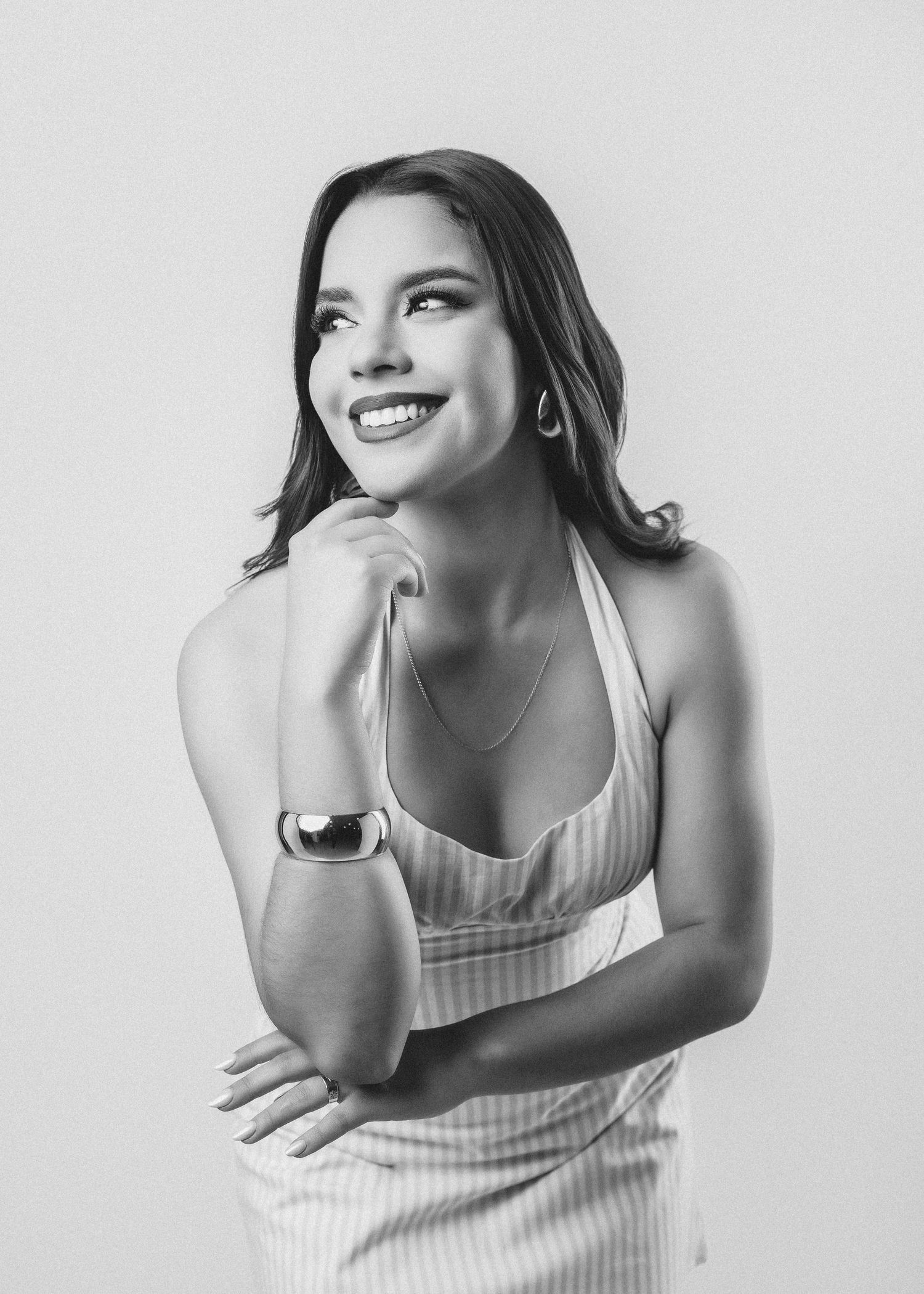A series of black and white portraits showing a person in a white tank top posing expressively against a light background.