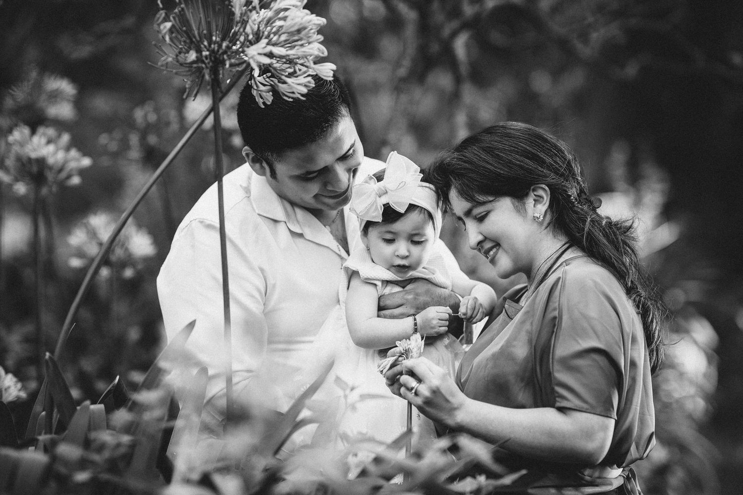 A couple shares joyful laughter together during an intimate black and white outdoor photoshoot.