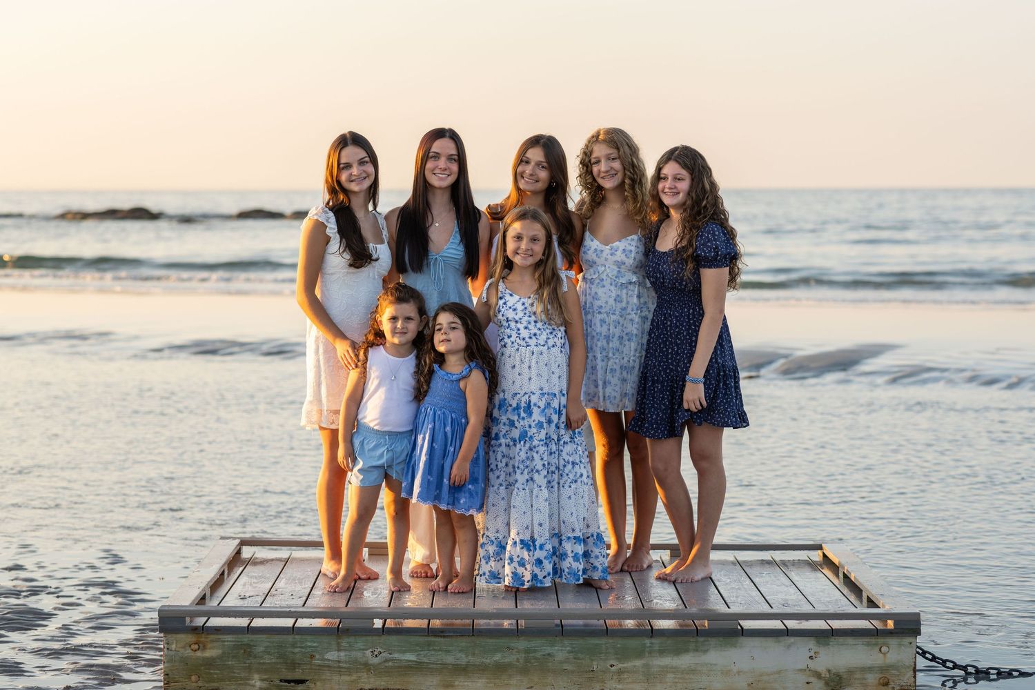 Group enjoying a summer evening on wooden boardwalk at the beach.