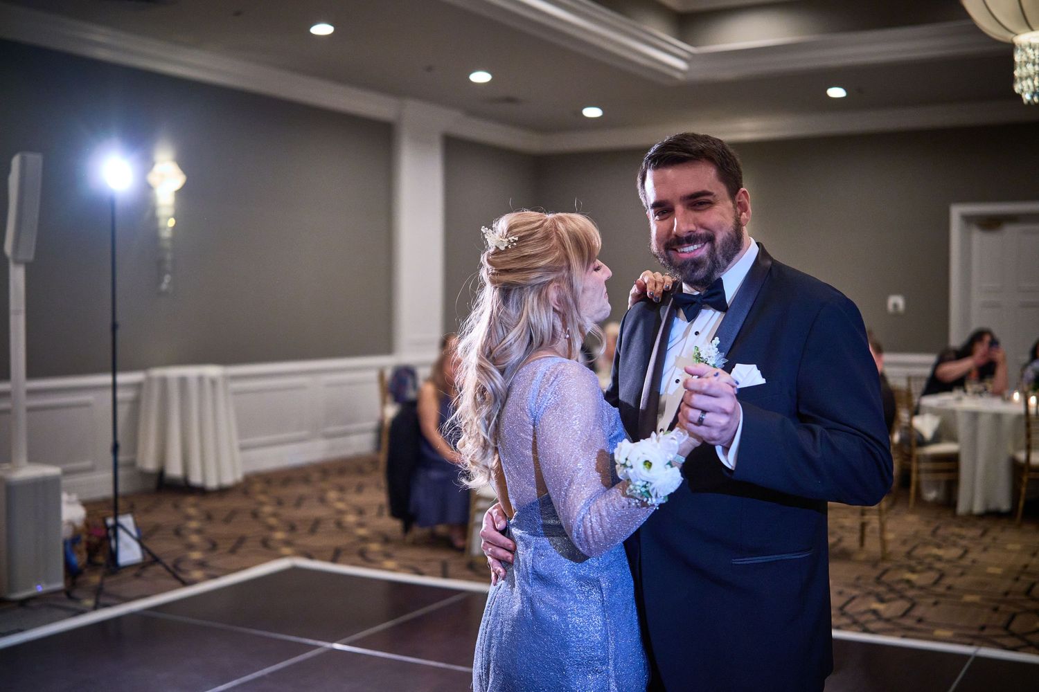 Wedding reception venue with dance floor and elegant lighting setup.