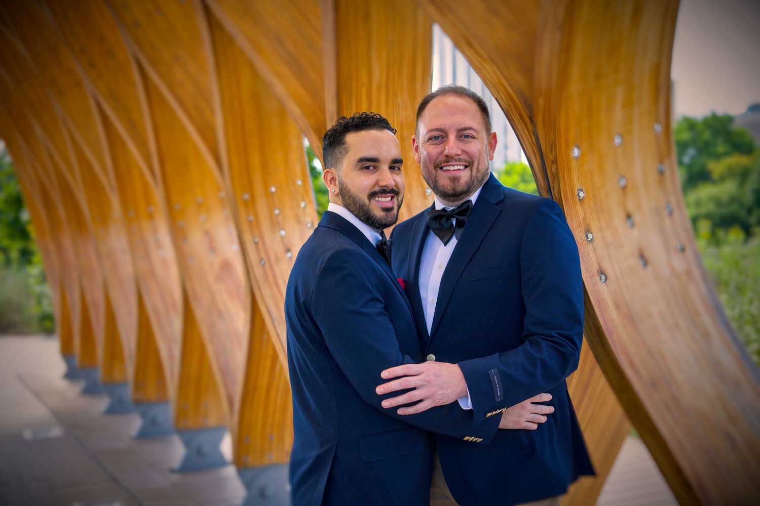 Candid moments between two people in navy suits under a wooden archway.